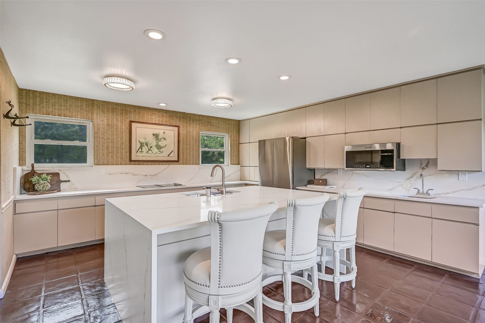 300 Courtlandt Place, Friendswood, TX 77546 Extensive cabinetry lines the kitchen walls, offering an abundance of storage alongside stainless appliances, an electric cooktop, built-in microwave & double ovens. A convenient secondary sink provides an additional prep area, while the oversized island anchors this spacious 2024 renovation.