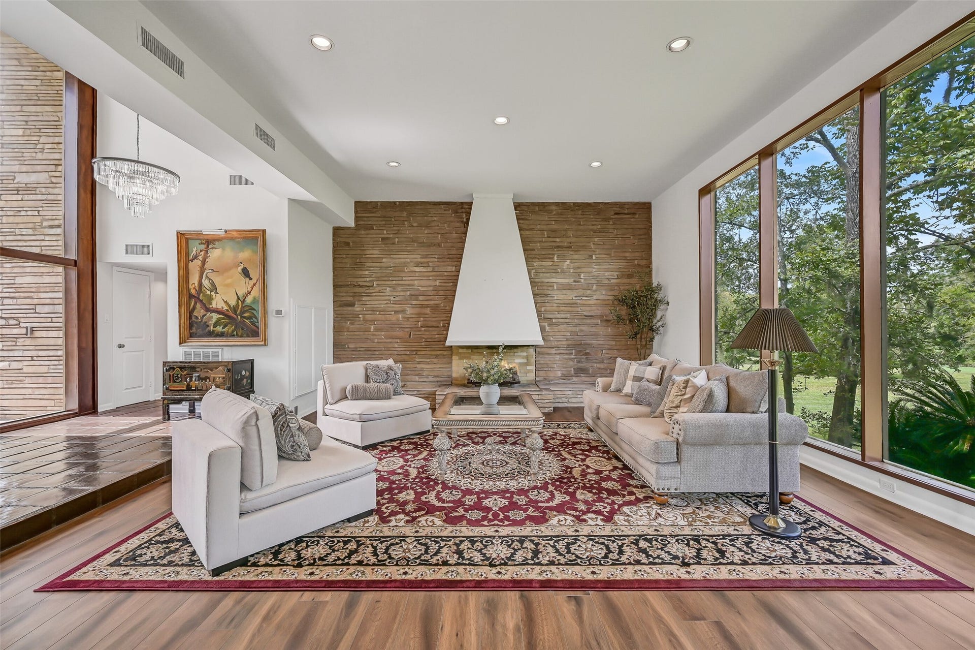300 Courtlandt Place, Friendswood, TX 77546 A closer look at the distinctive gas-log fireplace reveals its impressive stone accent wall, sculptural stucco hood & extended raised hearth. This dramatic architectural feature anchors the spacious living room, combining the home's original contemporary character with its updated interior finishes.