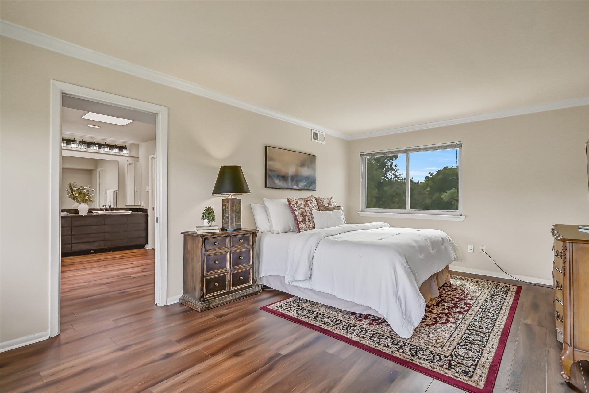 300 Courtlandt Place, Friendswood, TX 77546 Privately situated on the upper level, the primary suite features wood-look flooring, crown molding & large windows offering views of the surrounding trees. A dedicated sitting area provides additional room to unwind, while the adjoining primary bathroom offers dual sinks & separate bathing spaces.