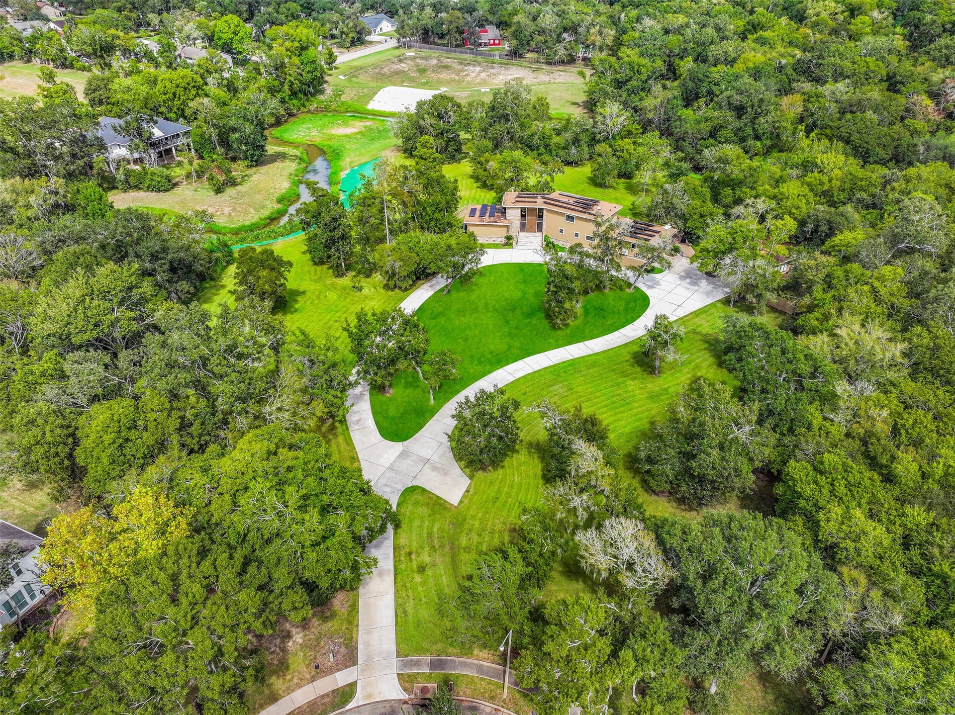300 Courtlandt Place, Friendswood, TX 77546 The home's sprawling footprint is surrounded by established trees & expansive green space, with a long driveway connecting the residence to the cul-de-sac. Notice the detached garage, extensive parking areas & multiple outdoor spaces that take advantage of the acreage.