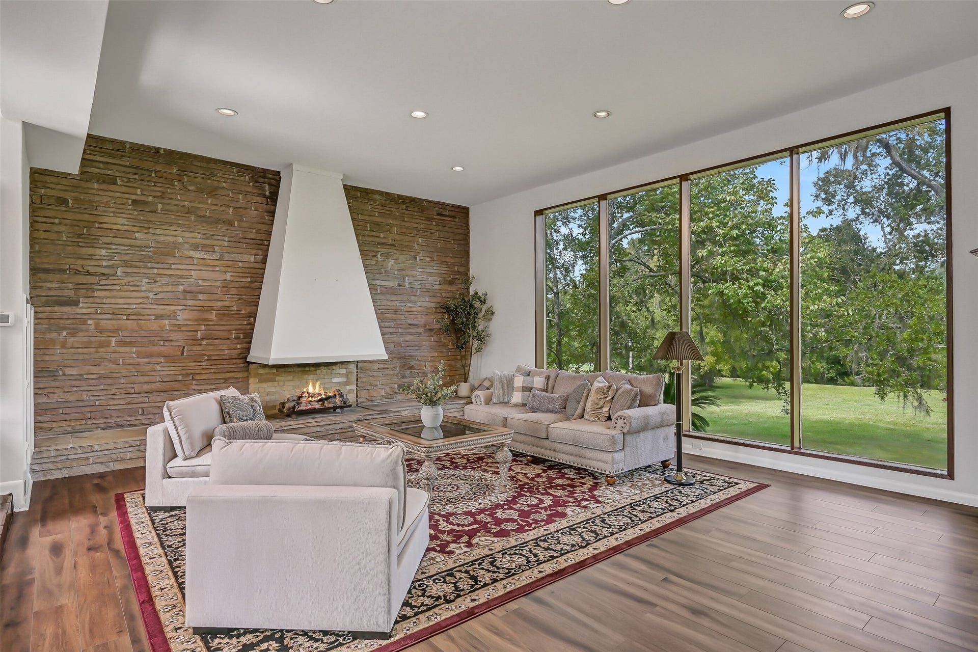 300 Courtlandt Place, Friendswood, TX 77546 From this perspective, the sunken living room's remarkable size and architectural character are especially apparent. Wood-look flooring, recessed lighting & a 12' ceiling complement the dramatic fireplace, while expansive windows and French doors connect the interior with the outdoor setting.