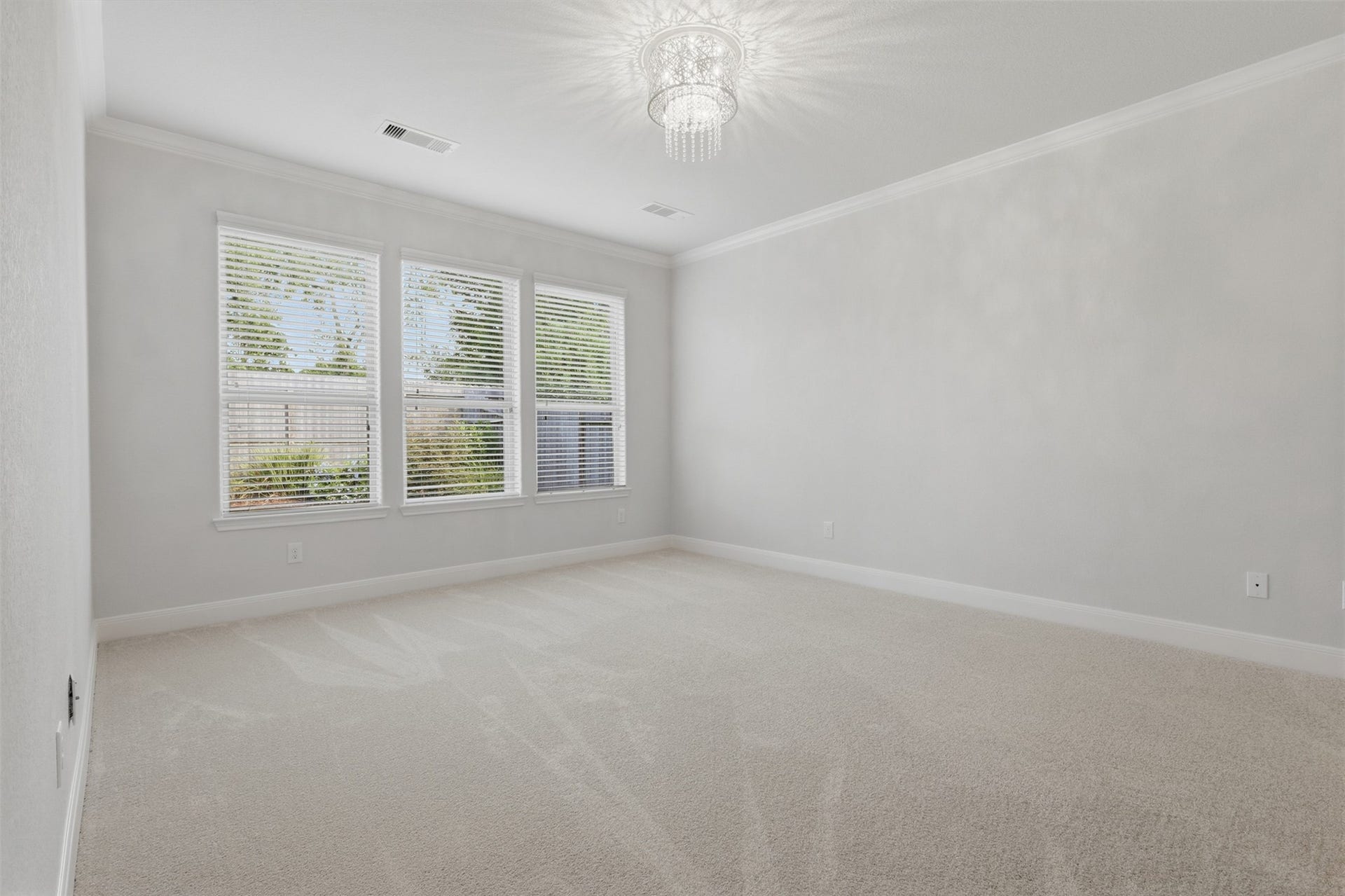 677 Tenuta Lane, League City, TX 77573 Spacious primary retreat filled with natural light and featuring plush carpeting, crown molding, and an elegant decorative light fixture. The private ensuite is accessed through double doors and offers a walk-in shower and generous walk-in closet, creating a comfortable and peaceful owners retreat.