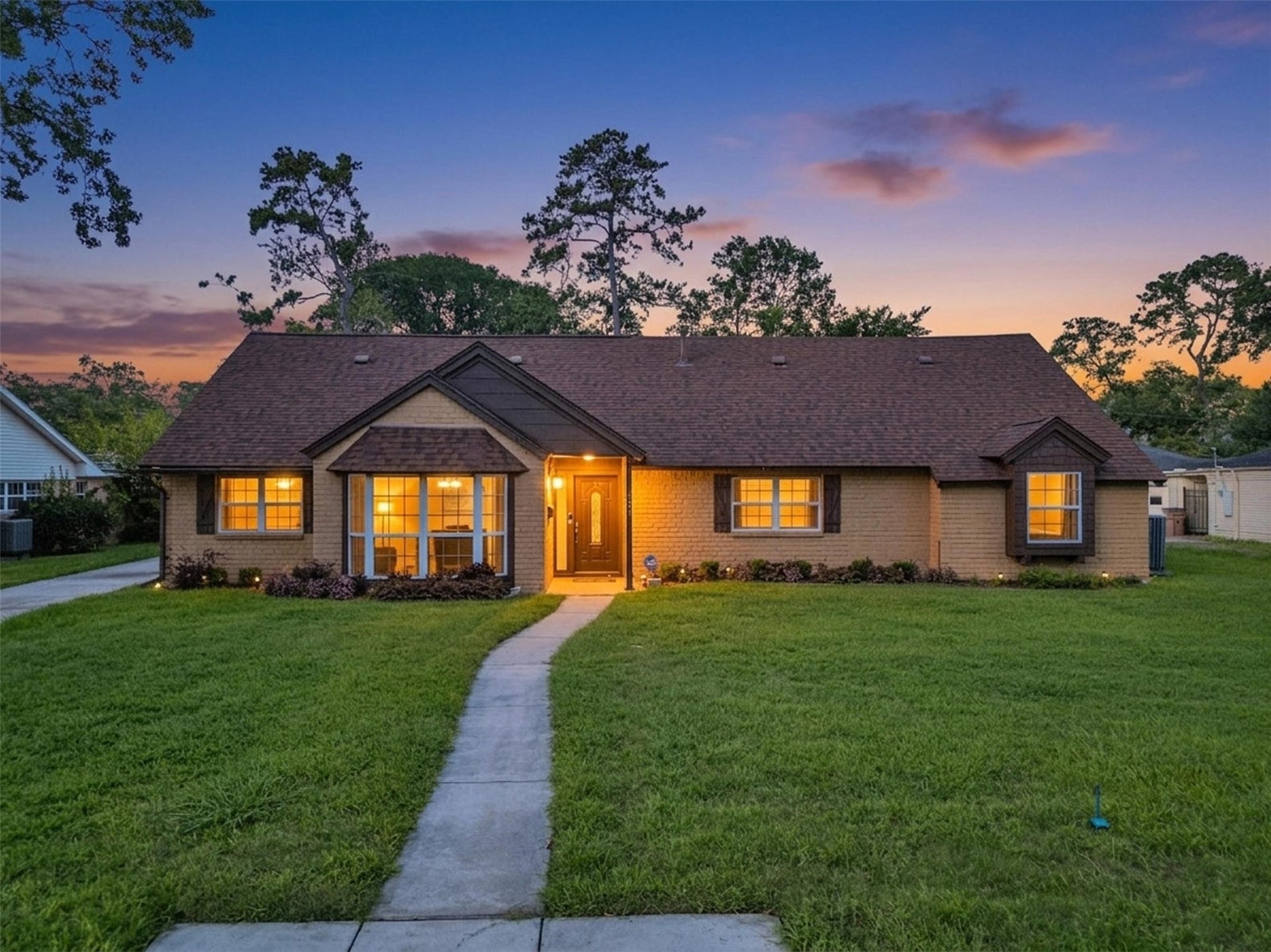 3017 Inwood Drive, Dickinson, TX 77539 A stunning story-and-a-half family home glows beautifully at twilight, welcoming you with warm lighting, timeless curb appeal, and plenty of space for everyday living and entertaining.