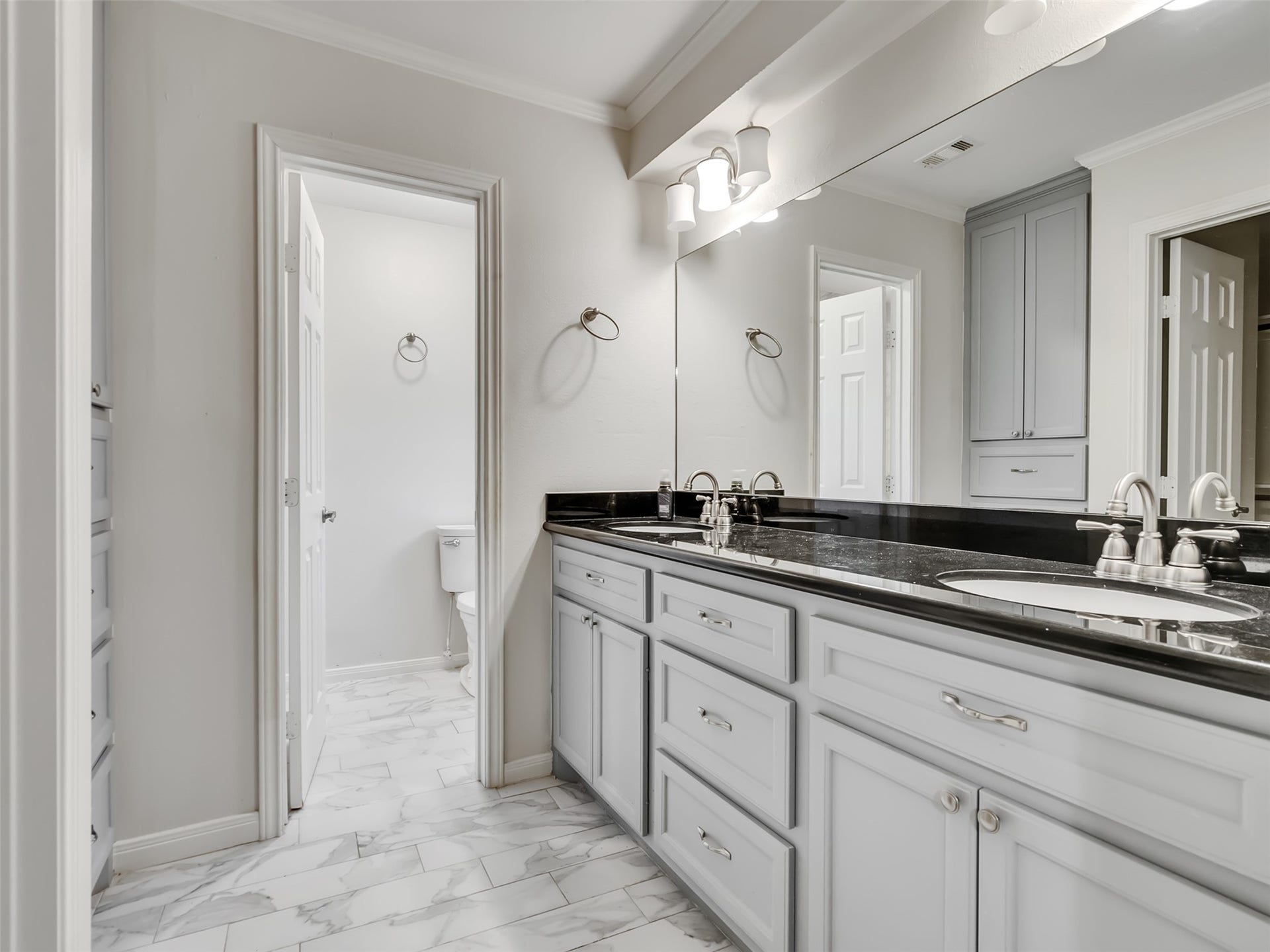 3017 Inwood Drive, Dickinson, TX 77539 A private retreat designed for comfort and style. This beautiful primary bath features granite countertops, dual sinks, and elegant built-ins that provide both luxury and functionality.