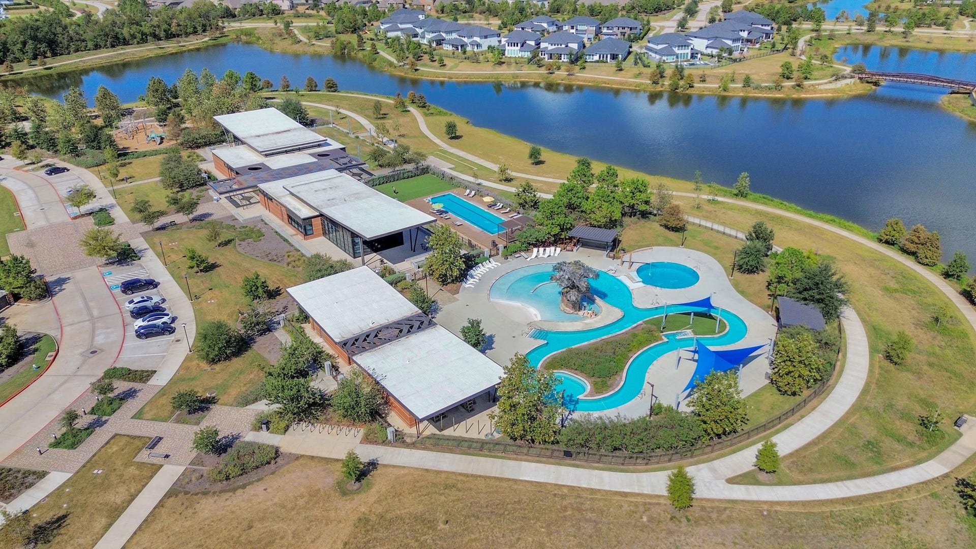 16506 Texas Hill Country Rd, Cypress, TX 77433 The aerial view captures the community's resort-style pool and scenic walking trail winding around the lake, providing a picturesque setting for relaxation and outdoor activities.