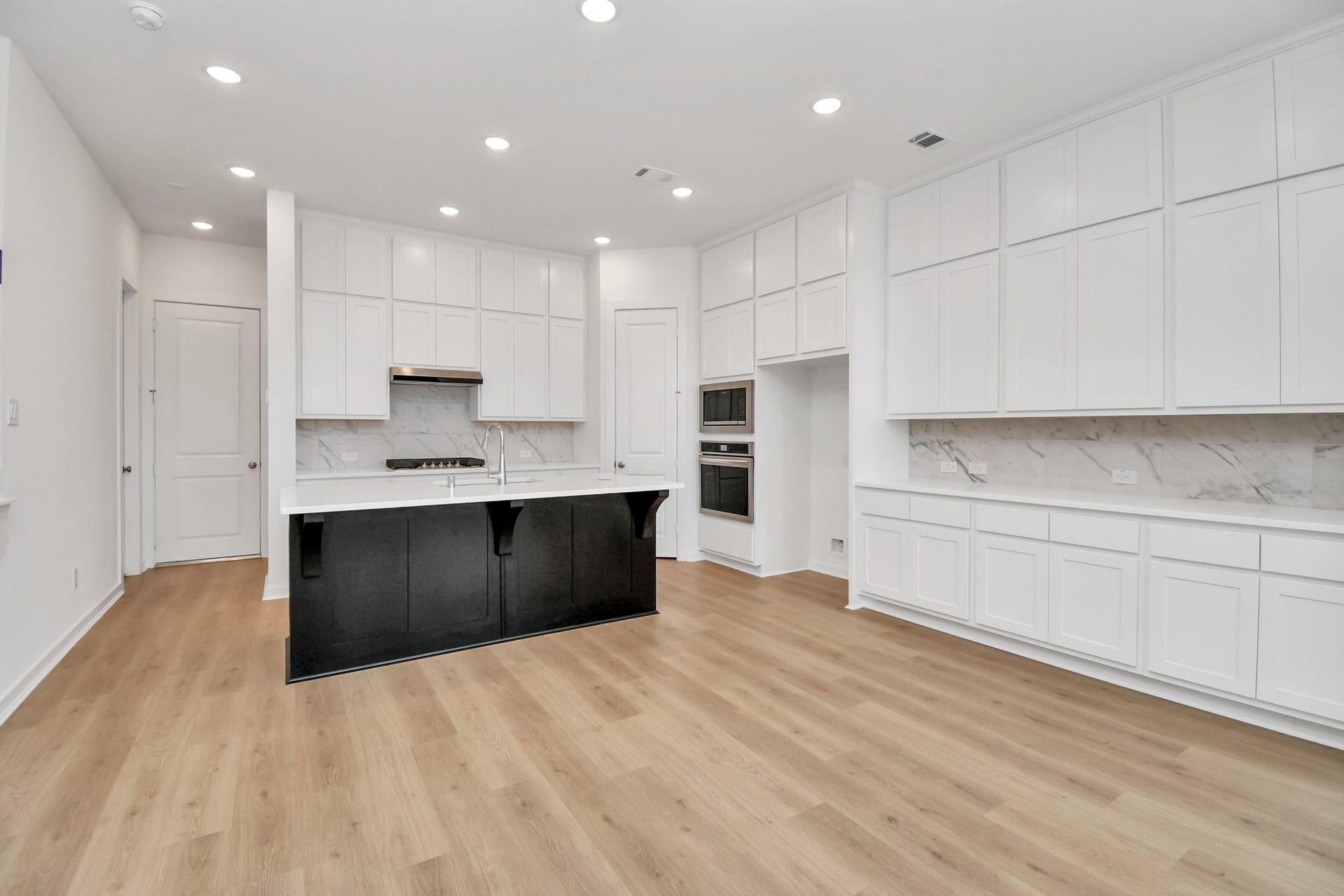 16506 Texas Hill Country Rd, Cypress, TX 77433 The kitchen, open to the living room, features ample cabinet storage and sleek stainless steel appliances for a modern touch.