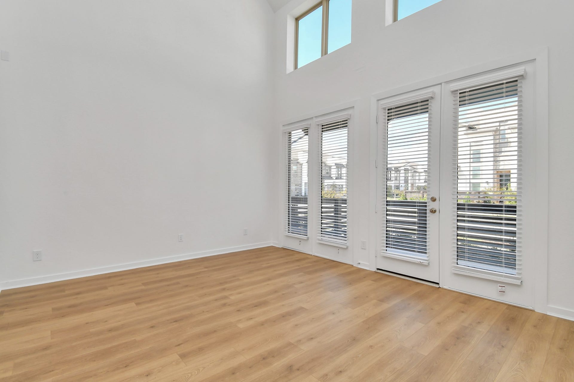 16506 Texas Hill Country Rd, Cypress, TX 77433 The living room features soaring high ceilings and expansive windows that fill the space with light, along with direct access to the front patio for easy indoor-outdoor living.