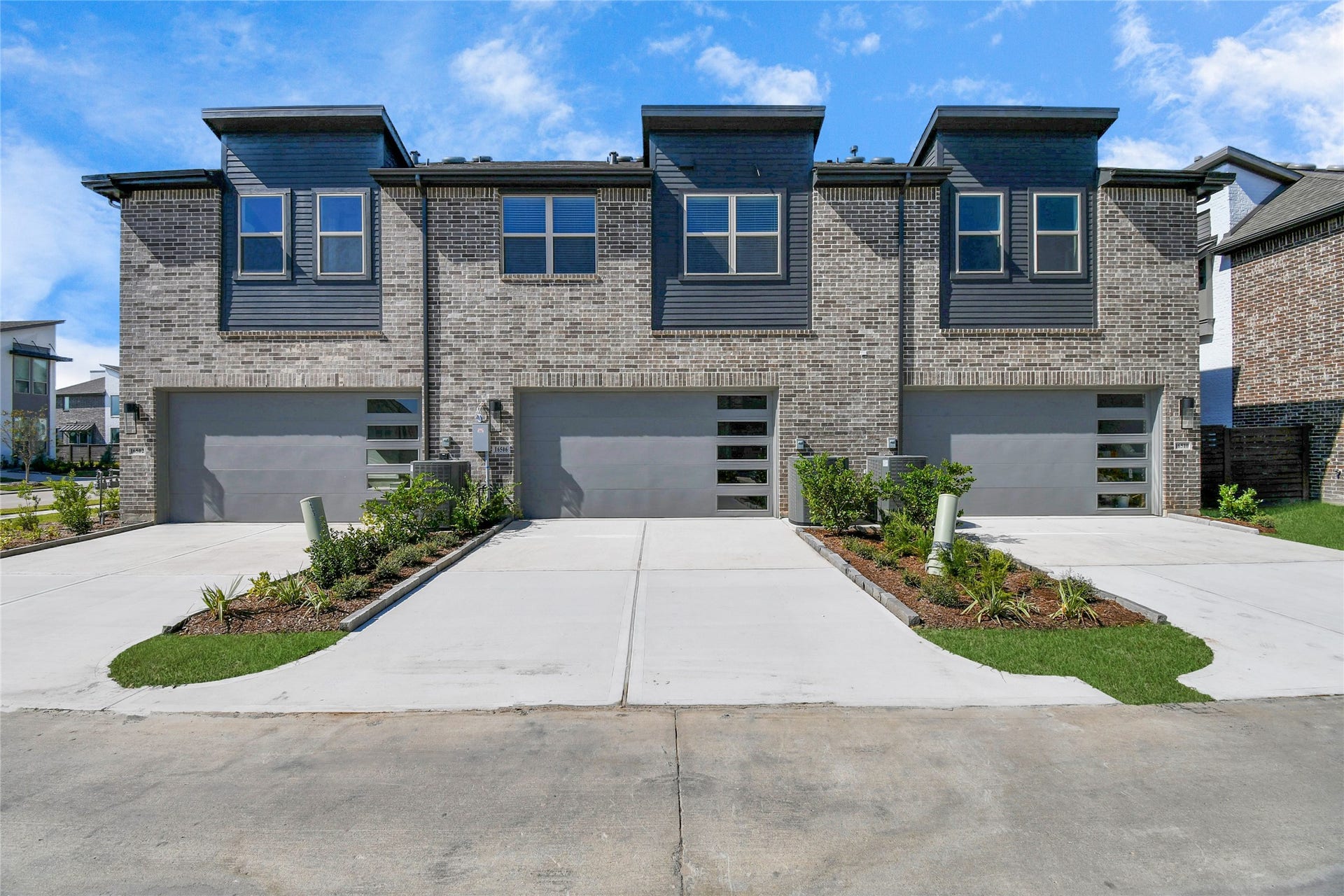 16506 Texas Hill Country Rd, Cypress, TX 77433 The back of the townhome showcases a stylish garage, seamlessly integrated into the modern design and enhancing the overall curb appeal.