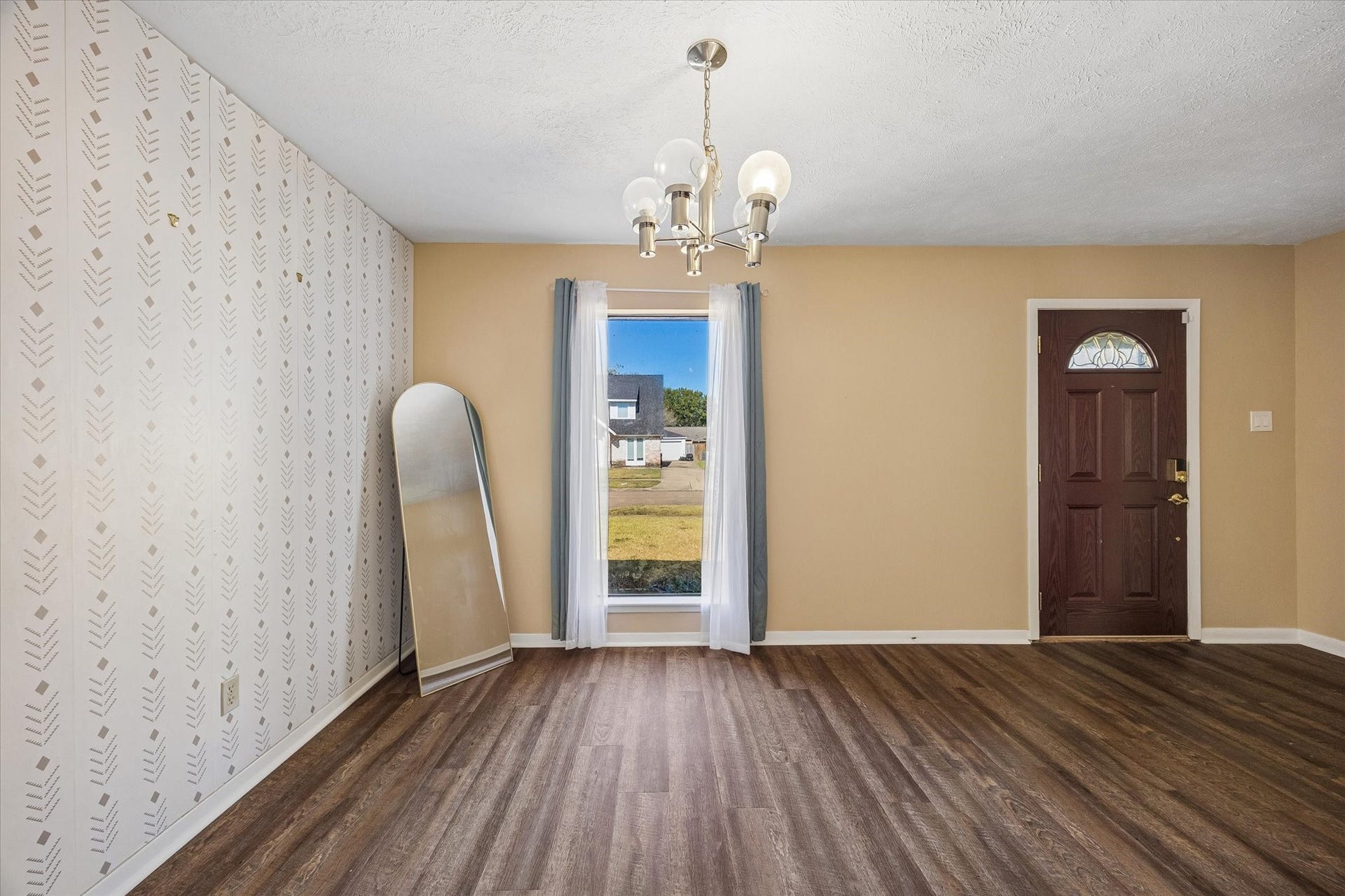 10110 Sagemill Drive, Houston, TX 77089 Charming entryway features elegant flooring, a stylish accent wall, and a classic chandelier, creating a welcoming atmosphere.