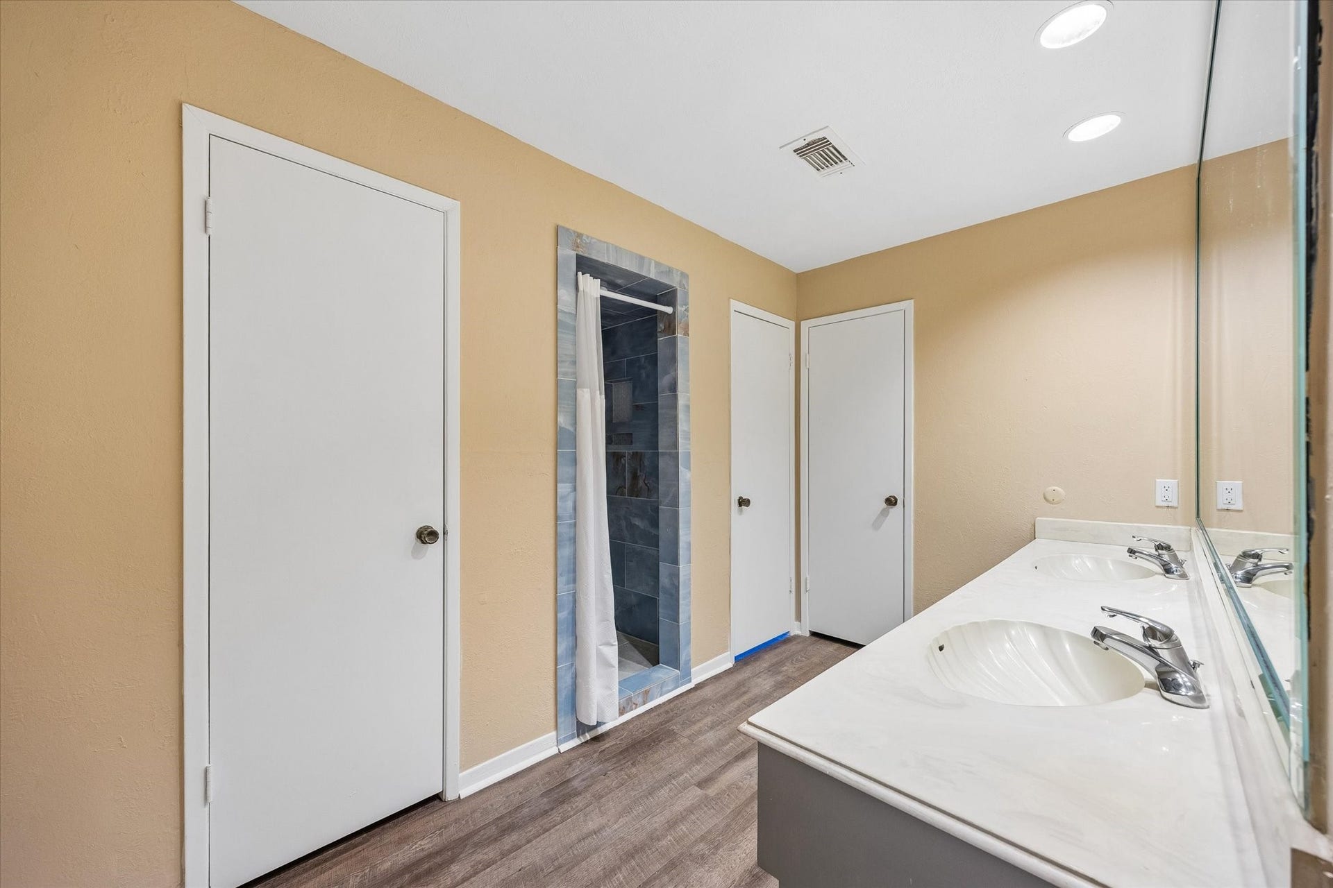 10110 Sagemill Drive, Houston, TX 77089 Spacious bathroom featuring a dual-sink vanity, warm-toned walls, and a sleek, tiled shower area.
