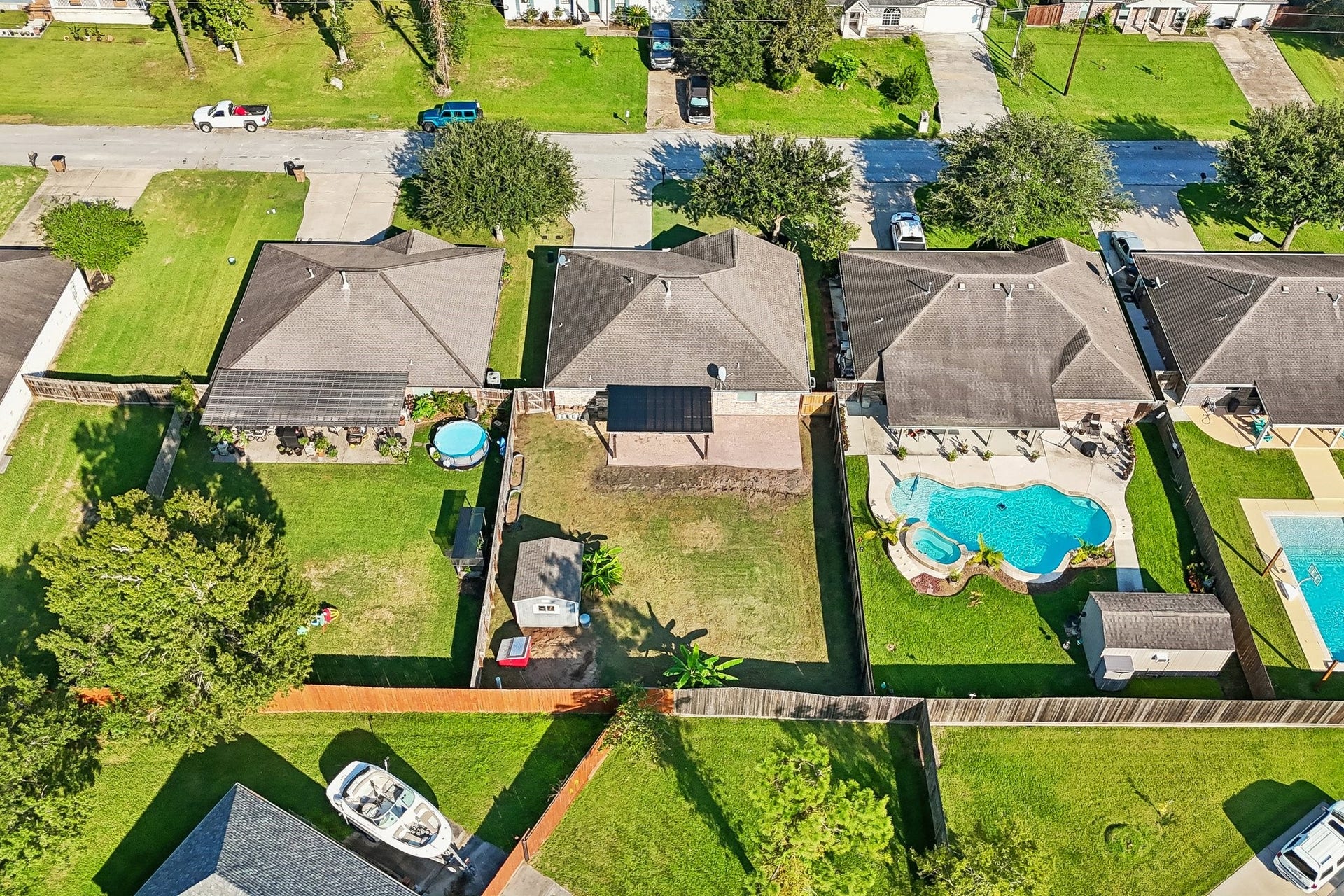 5012 Bayou Dr, Dickinson, TX 77539 Charming suburban neighborhood with well-maintained homes featuring spacious backyards. A standout property includes a sparkling pool and a cozy patio area, perfect for outdoor relaxation and entertaining.