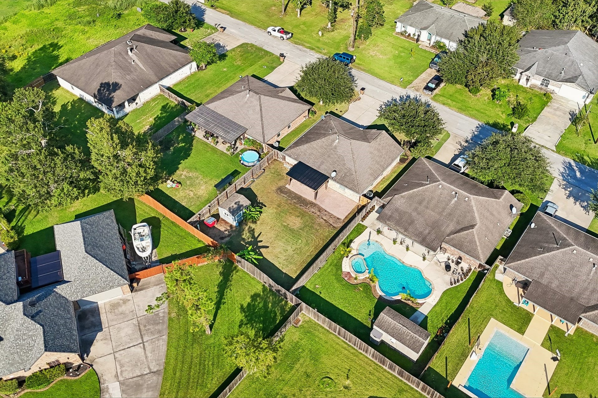 5012 Bayou Dr, Dickinson, TX 77539 Charming neighborhood featuring spacious yards, a beautiful in-ground pool, and lush greenery, perfect for family living and outdoor activities.