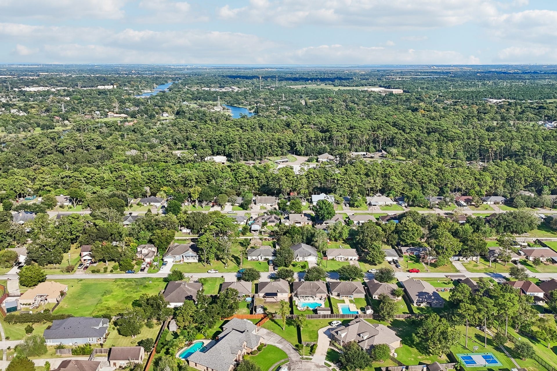5012 Bayou Dr, Dickinson, TX 77539 Charming suburban neighborhood with lush greenery, spacious homes, and inviting pools, offering a serene and picturesque setting.