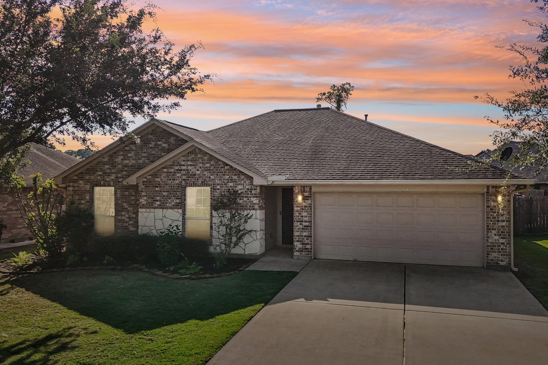 5012 Bayou Dr, Dickinson, TX 77539 Charming brick home with a spacious two-car garage, nestled in a serene neighborhood. The beautifully manicured lawn and mature trees create a welcoming curb appeal.