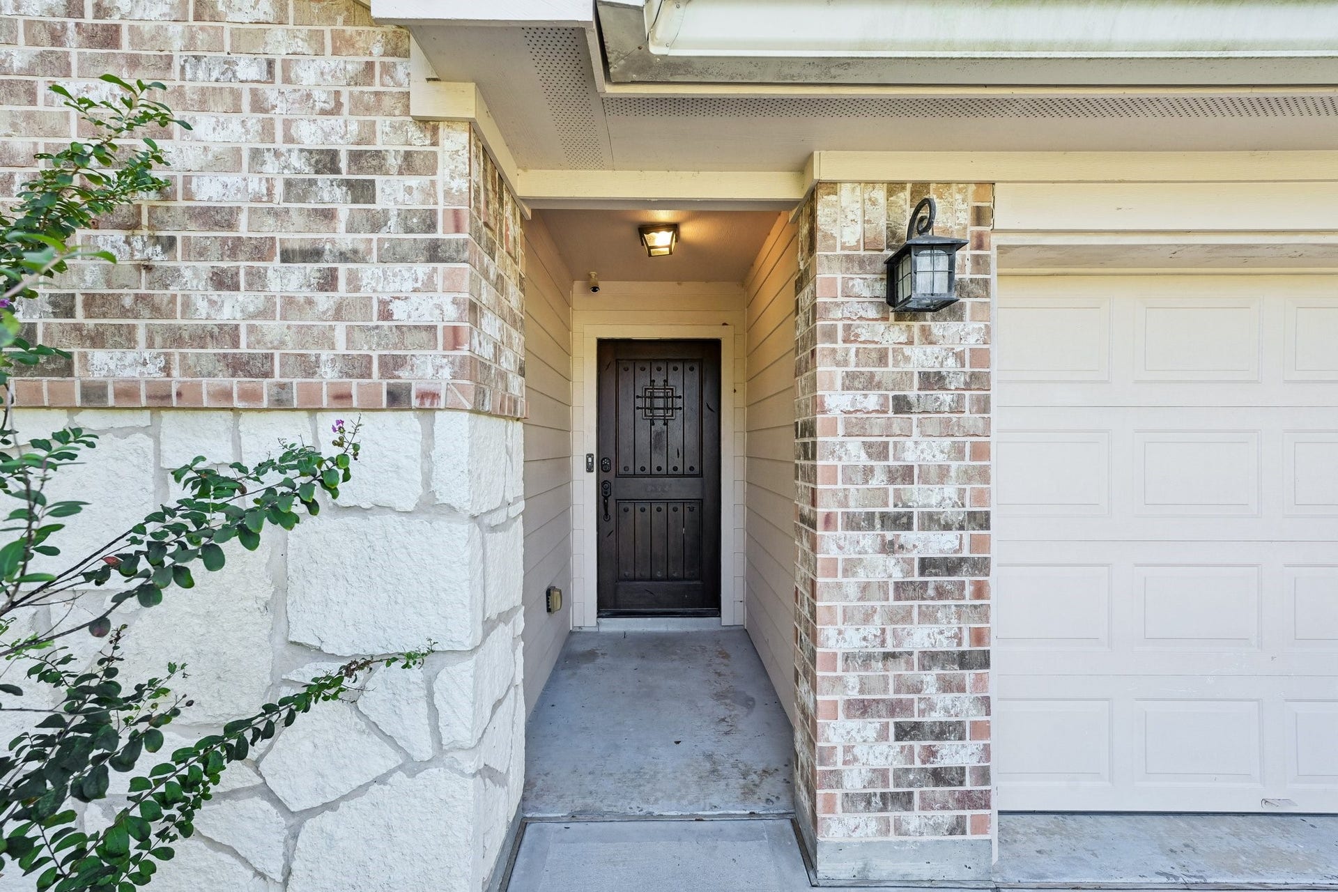 5012 Bayou Dr, Dickinson, TX 77539 Charming entrance with a mix of brick and stone detailing, featuring a sturdy front door and a welcoming porch area.