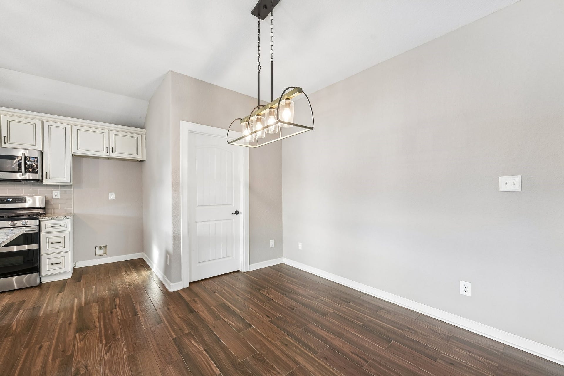 5012 Bayou Dr, Dickinson, TX 77539 Elegant dining area with modern lighting, hardwood floors, and easy access to the stylish kitchen featuring stainless steel appliances and sleek cabinetry.