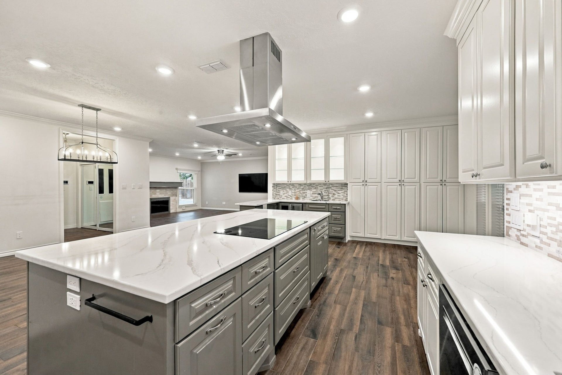 1430 Stependale Drive, Katy, TX 77450 Updated kitchen featuring a large gray island, white cabinetry, stainless steel appliances, and contemporary lighting.