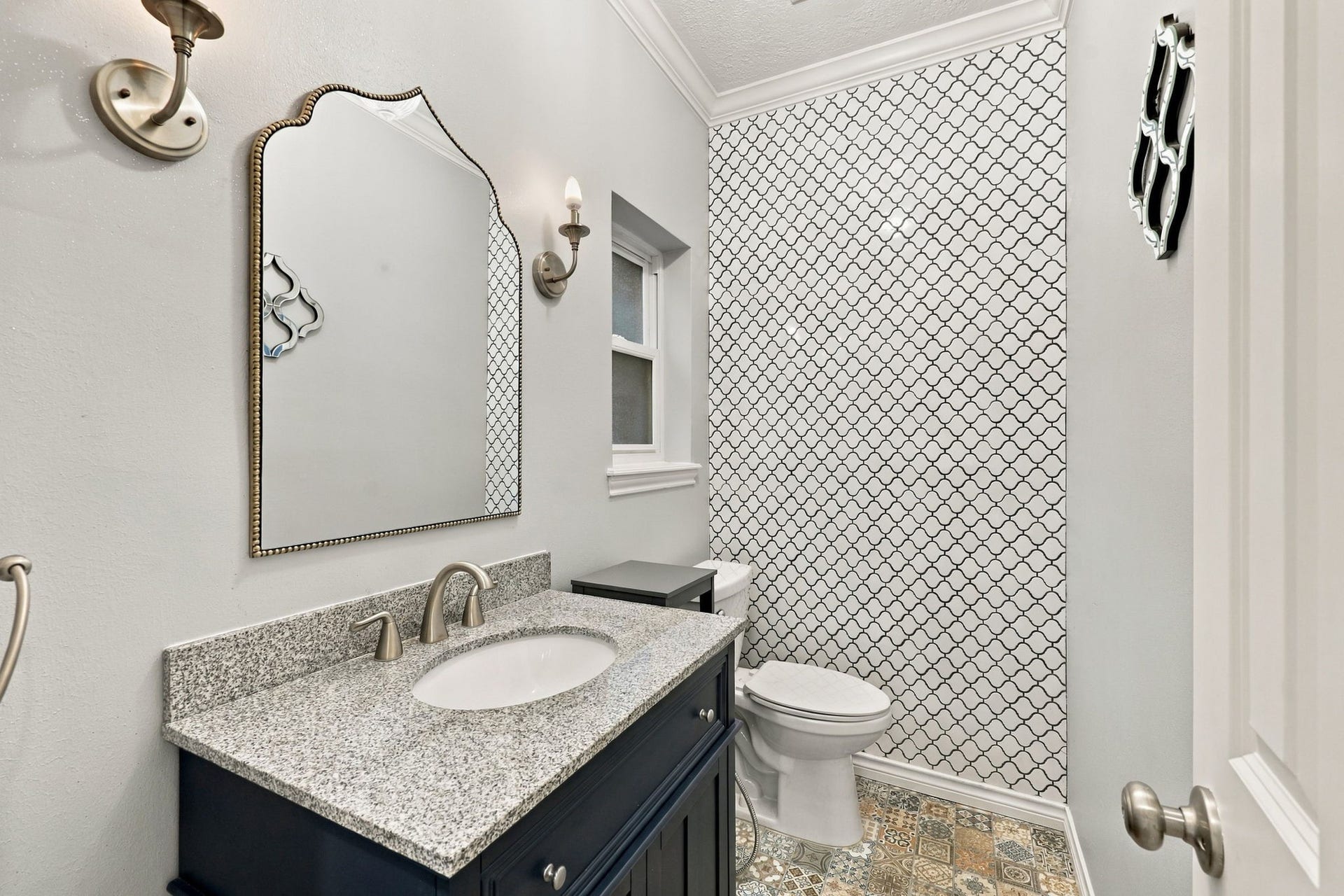 1430 Stependale Drive, Katy, TX 77450 Stylish half bath featuring a dark vanity, granite countertop, decorative patterned tile, and modern fixtures.