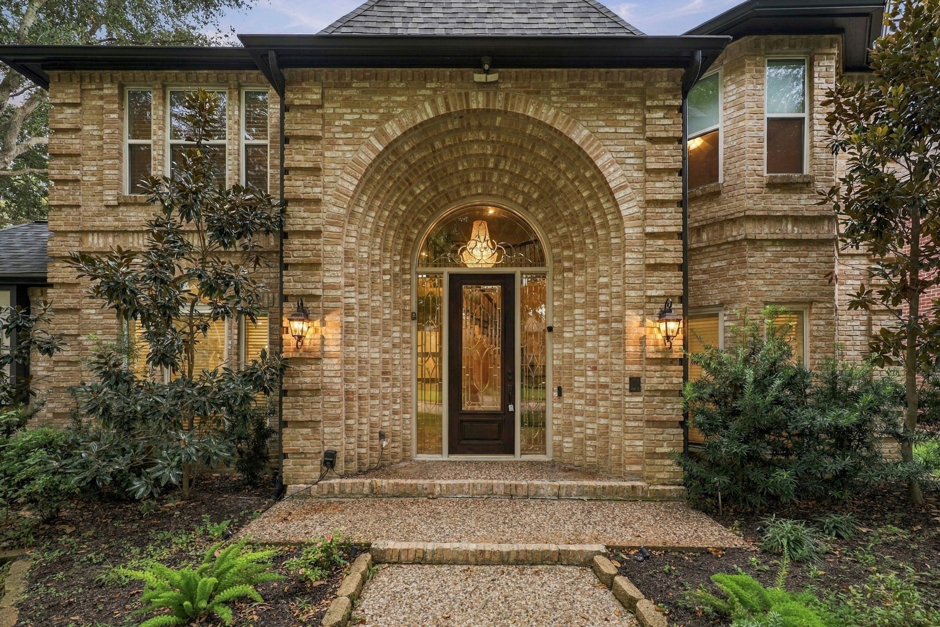 1430 Stependale Drive, Katy, TX 77450 Close-up view of the home's distinctive brick architecture, arched windows, and manicured landscaping.