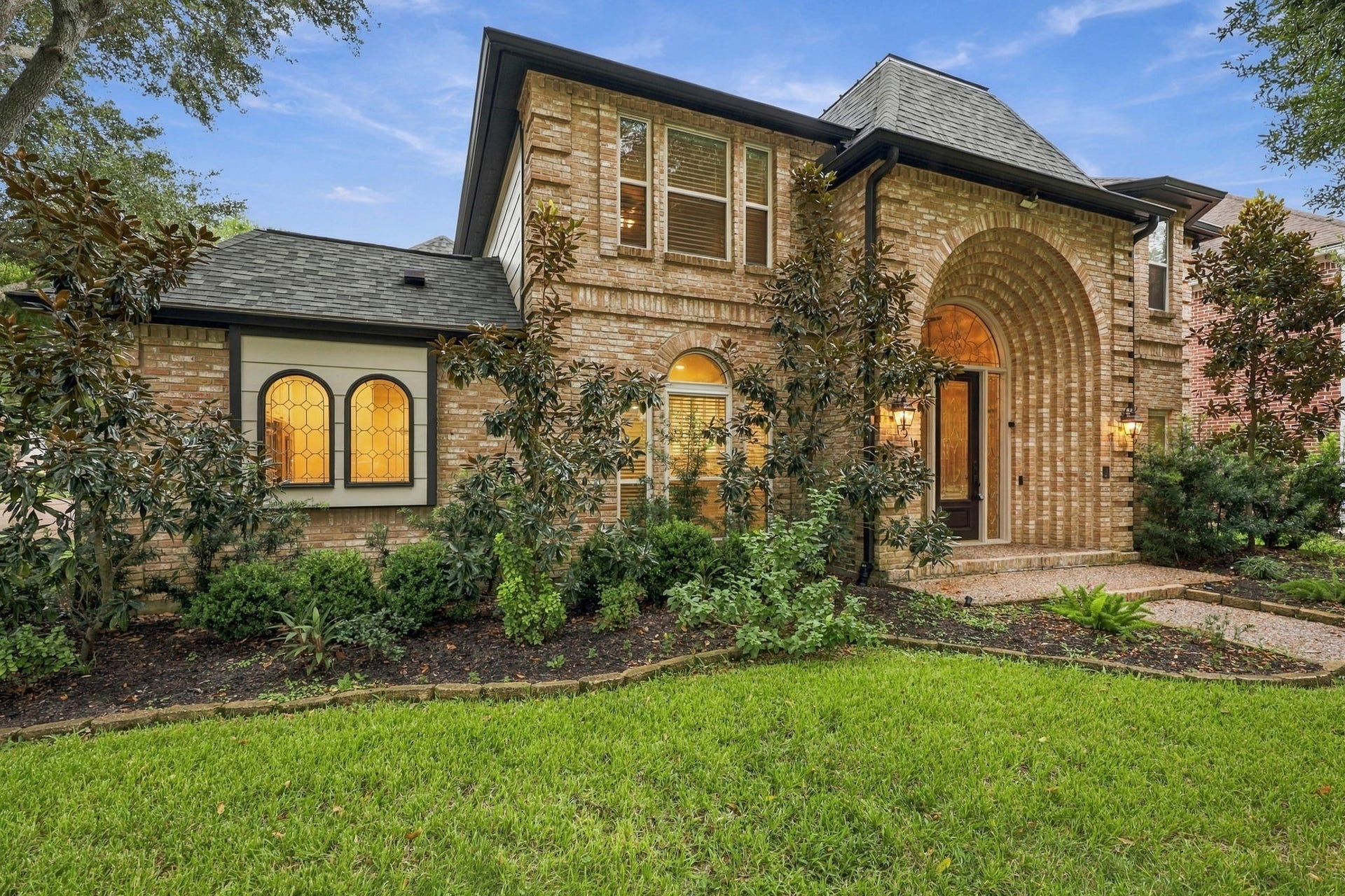 1430 Stependale Drive, Katy, TX 77450 Beautiful brick home featuring mature shade trees, lush landscaping, and an inviting front lawn.