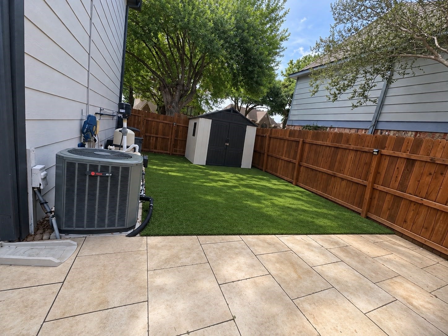 1430 Stependale Drive, Katy, TX 77450 Fenced side yard with green space and a paved patio area, offering additional outdoor utility and room for storage.