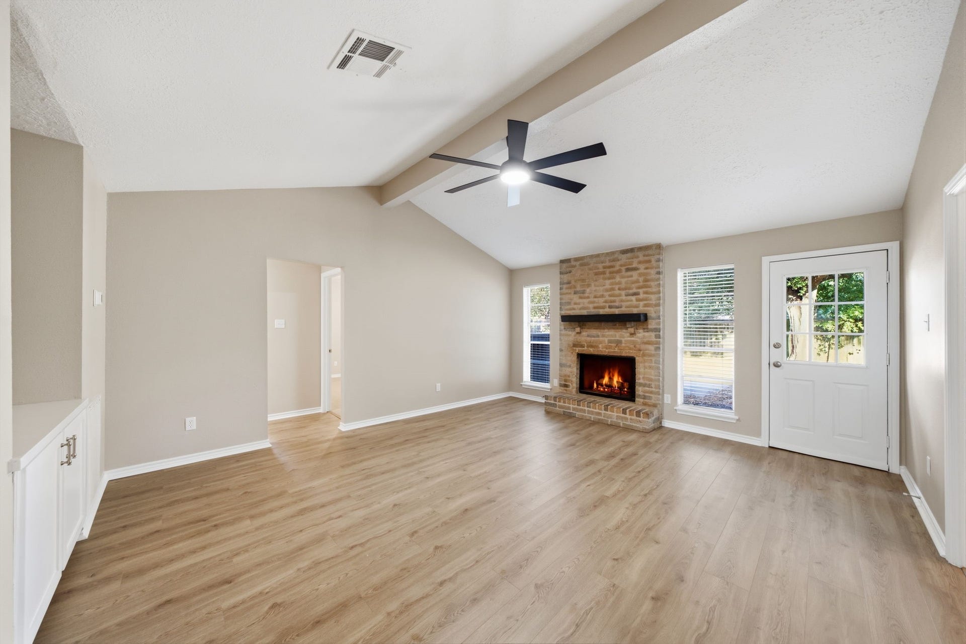 Living room featuring a beautiful brick fireplace.