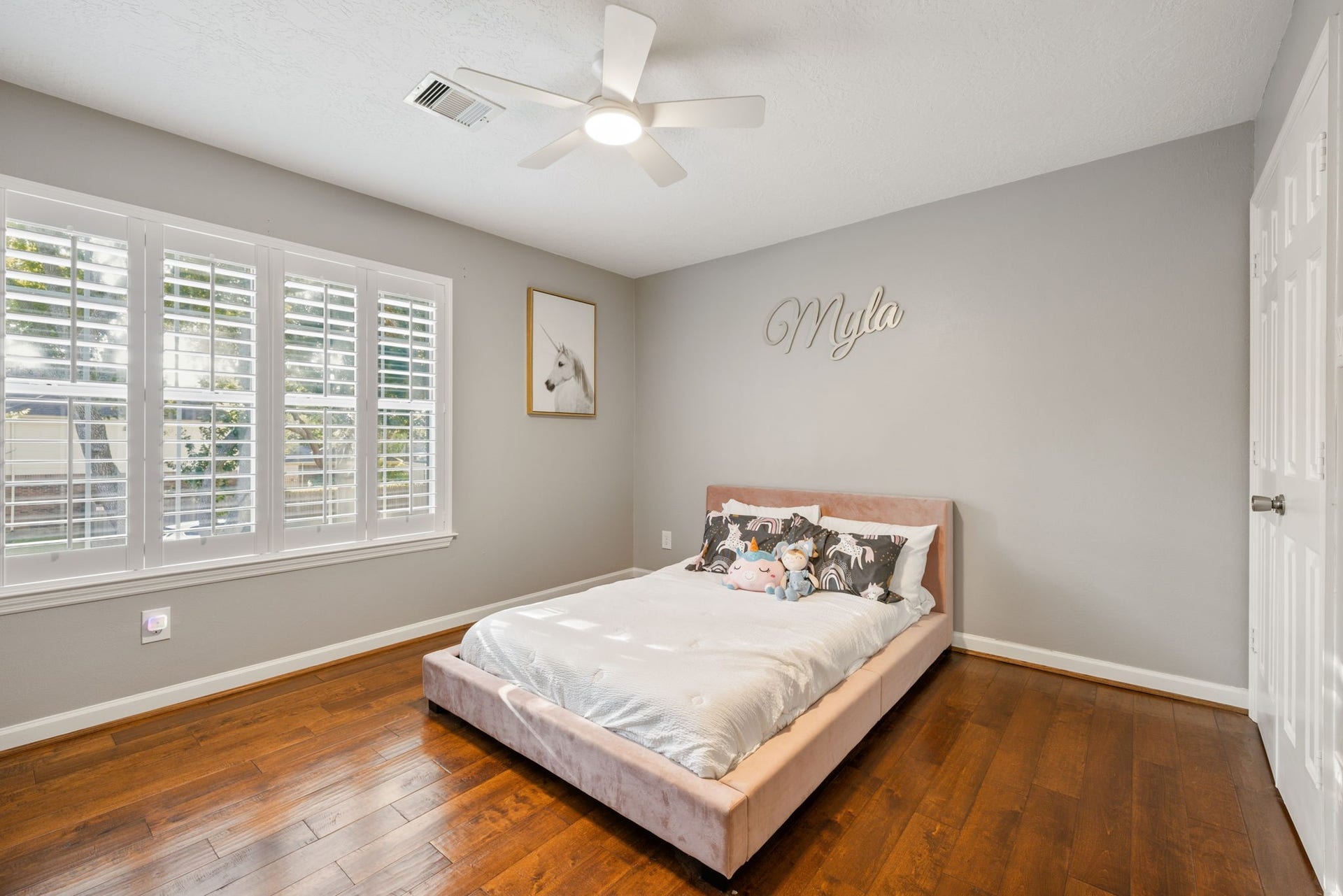 236 Sunset Ridge Drive, League City, TX 77573 Bright and inviting bedroom featuring hardwood flooring, plantation shutters, and a contemporary ceiling fan