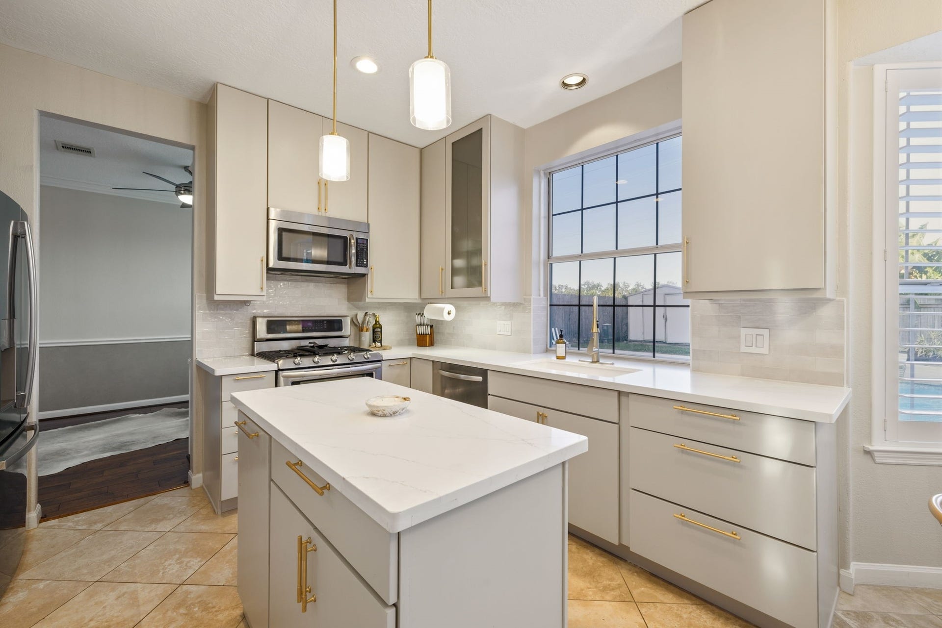 236 Sunset Ridge Drive, League City, TX 77573 Stylish pendant lighting, abundant storage, and a sunlit window overlooking the pool complete this inviting kitchen.