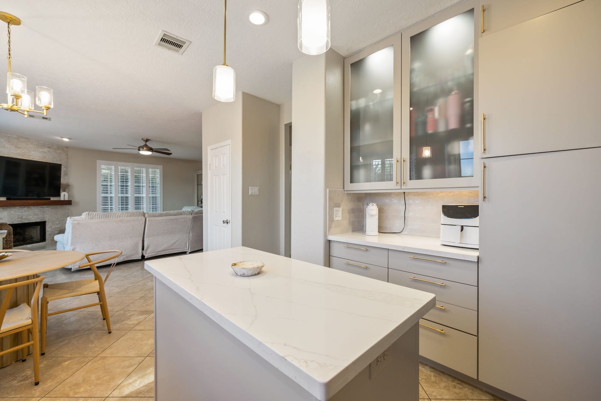 236 Sunset Ridge Drive, League City, TX 77573 Frosted-glass cabinetry, designer lighting, and an open layout elevate this beautifully appointed kitchen.