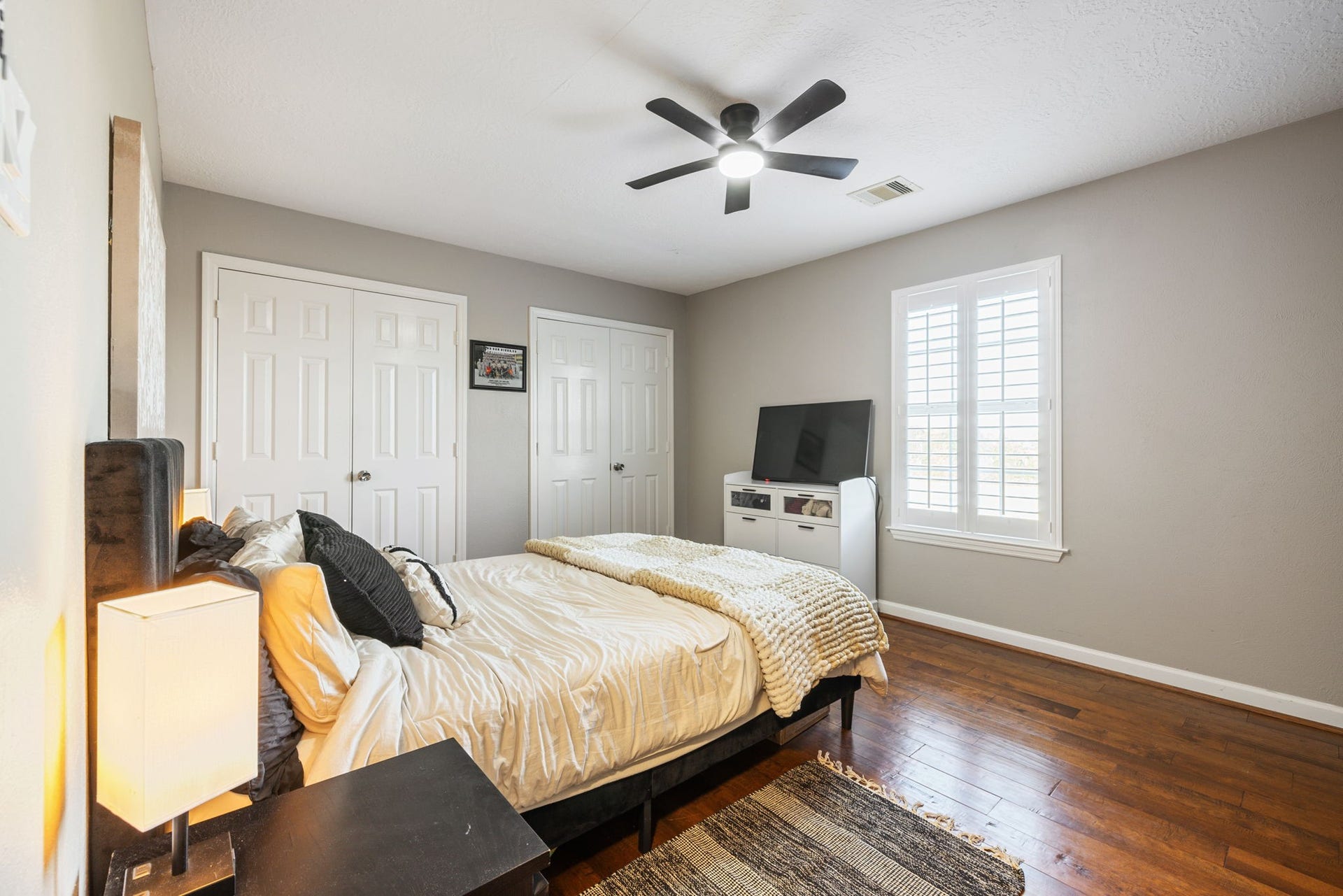236 Sunset Ridge Drive, League City, TX 77573 Another spacious bedroom with rich hardwood floors and a neutral paint color. There are also double closets and abundant natural light, creating a cozy and inviting atmosphere.