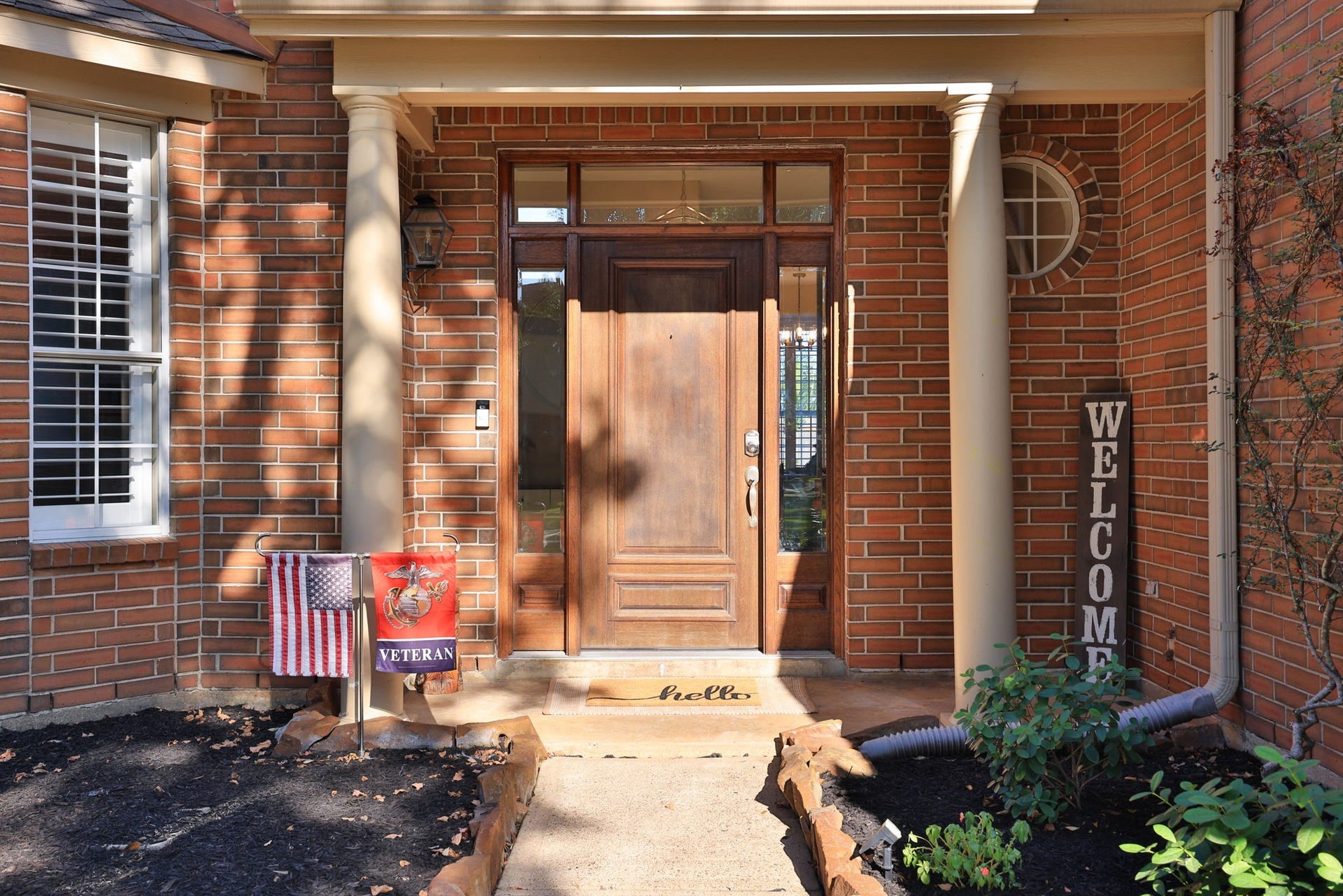236 Sunset Ridge Drive, League City, TX 77573 An inviting covered entry features stately columns, a rich wood door, and elegant glass sidelights.
