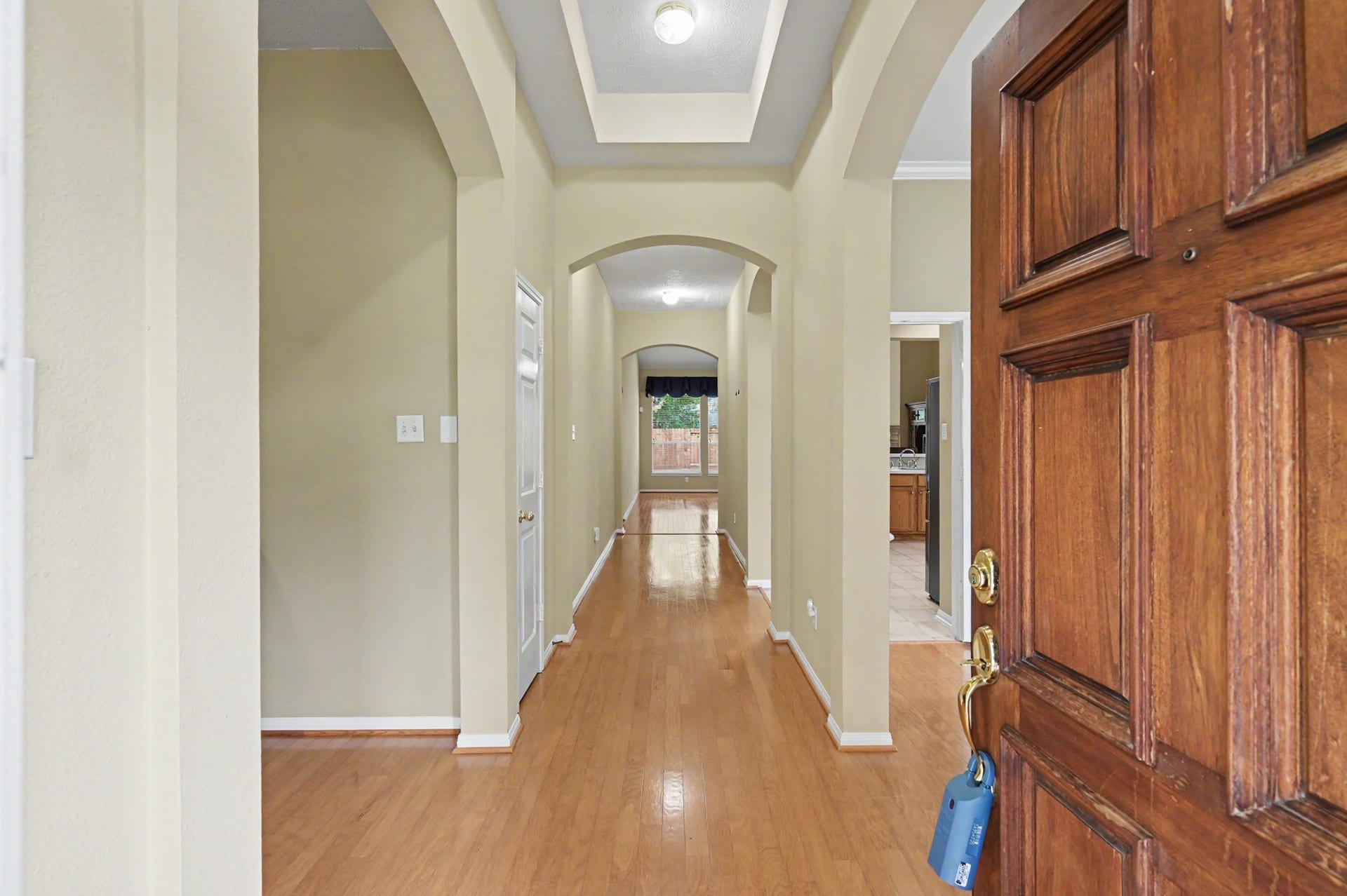 26 N Brooksedge Circle, The Woodlands, TX 77382 Entryway with wood floors, neutral paint, and tray ceilings. The formal living room/flex room/office space is to the left and the formal dining is to the right.