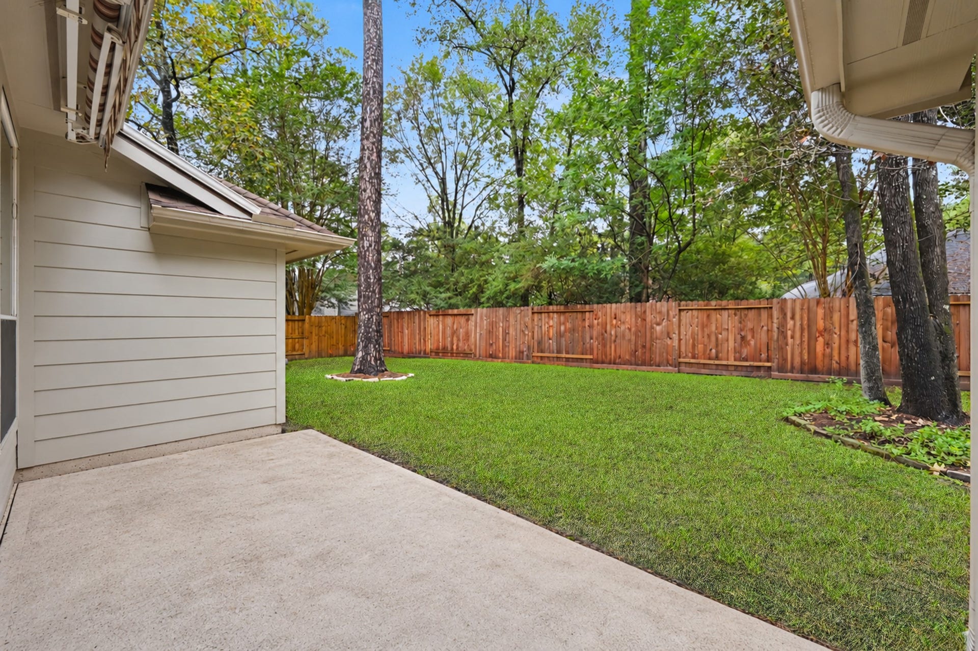 26 N Brooksedge Circle, The Woodlands, TX 77382 Enjoy the backyard from the patio with a retractable awning.