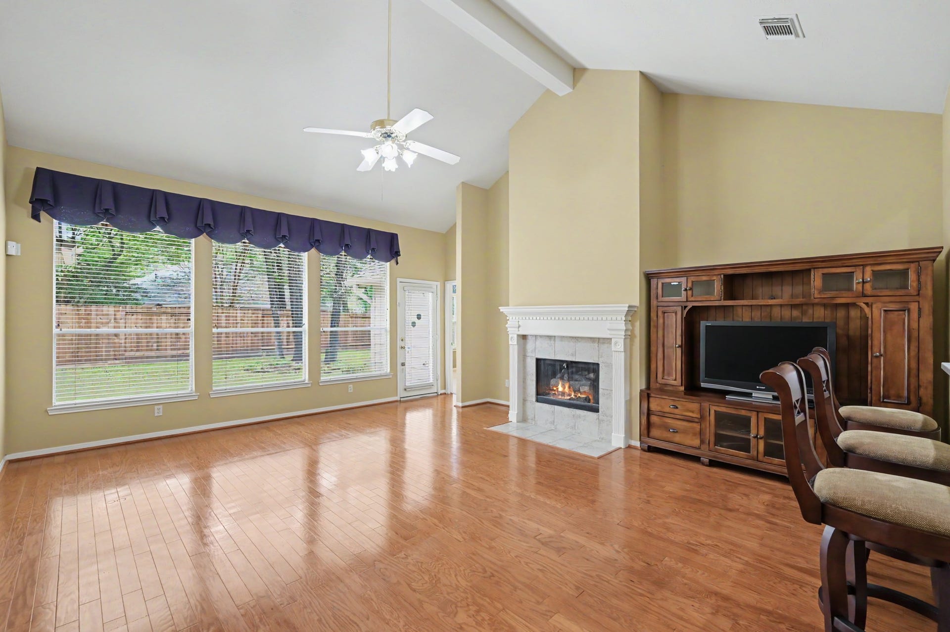 26 N Brooksedge Circle, The Woodlands, TX 77382 The main living room/den offers a vaulted ceiling, gas fireplace, and views of the backyard.