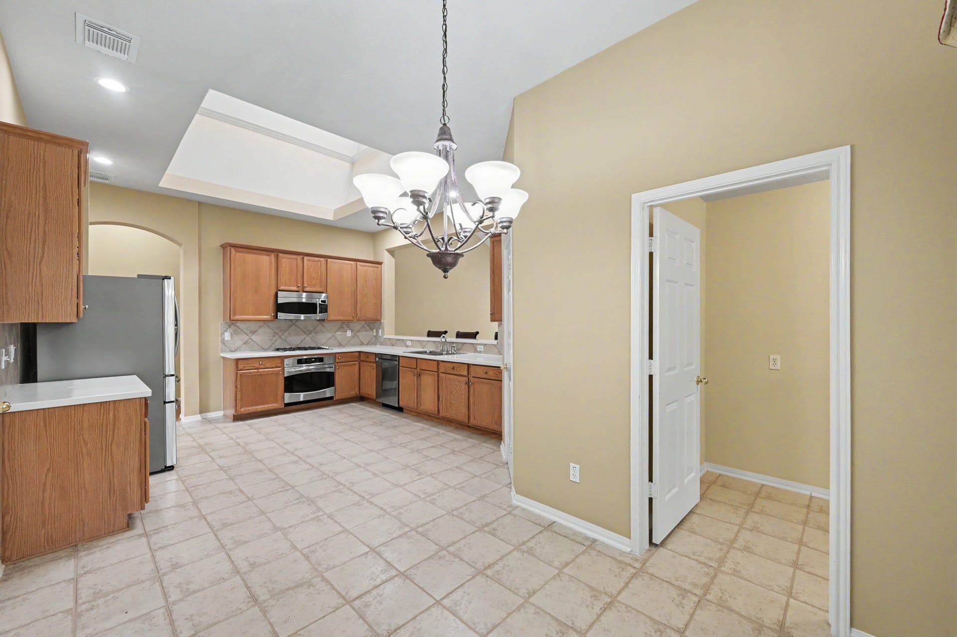 26 N Brooksedge Circle, The Woodlands, TX 77382 Alternate view of the kitchen from the breakfast nook. The utility room is located off of the breakfast nook.