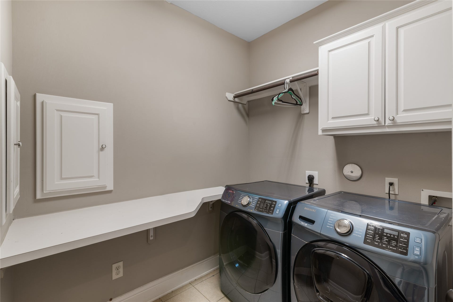 2525 W Ranch Drive, Friendswood, TX 77546 Well-appointed utility room with upper cabinetry for storage, functional counter space and laundry shoots from the master bedroom behind those doors on the left.