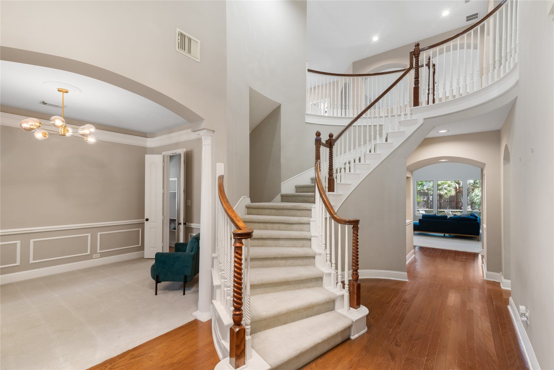 2525 W Ranch Drive, Friendswood, TX 77546 Elegant 2-story entry featuring a sweeping curved staircase, crisp white balusters, and warm wood accents.