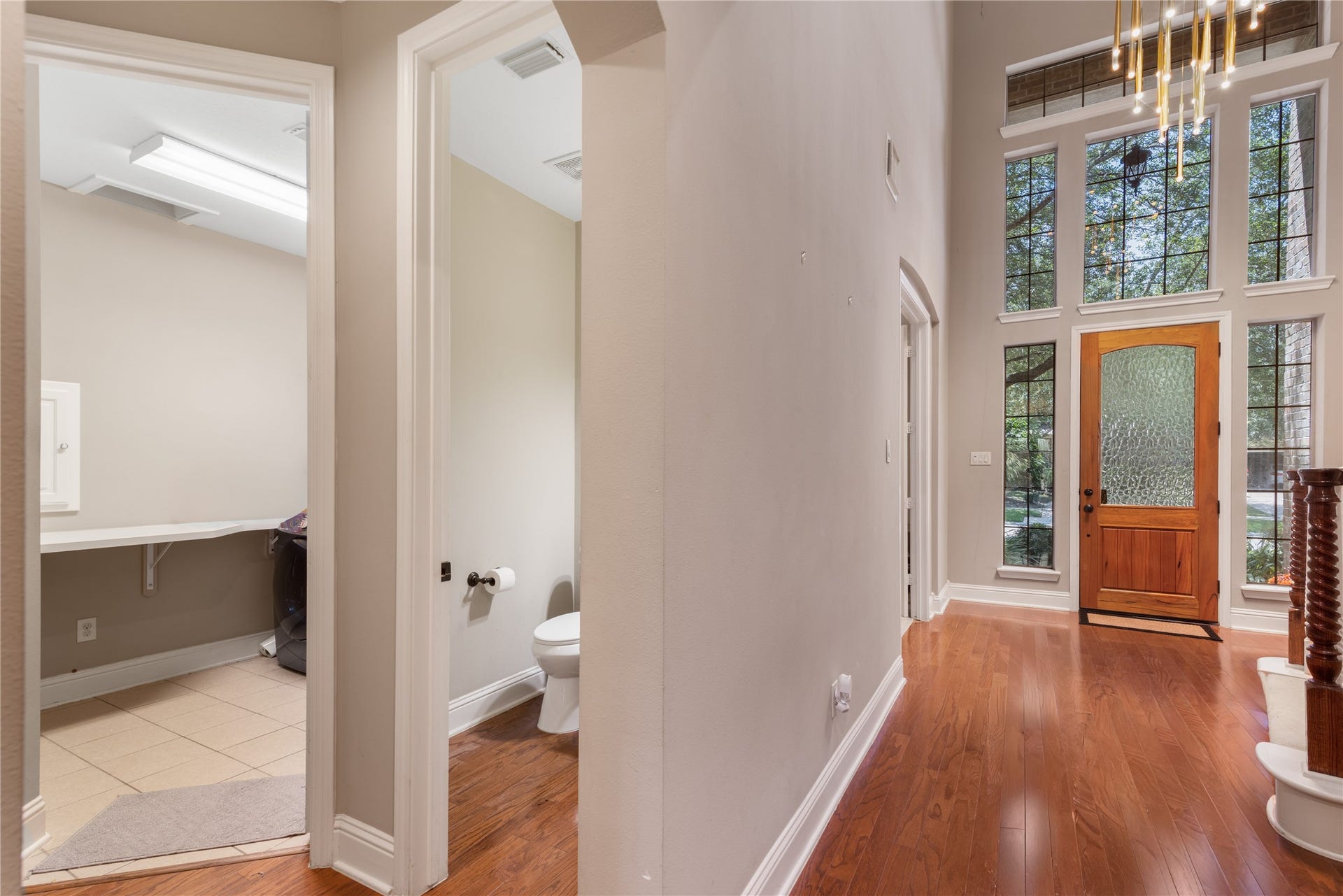 2525 W Ranch Drive, Friendswood, TX 77546 Beautiful entryway leads to the half bath and utility room, showcasing the home's functional layout and easy flow. The modern lighting and neutral tones create a bright, welcoming first impression.