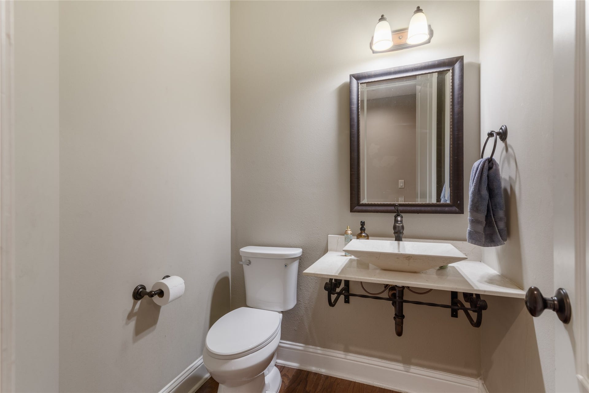 2525 W Ranch Drive, Friendswood, TX 77546 Stylish half bath featuring a modern vessel sink, warm toned floors and neutral tones creating an updated space perfect for guests.