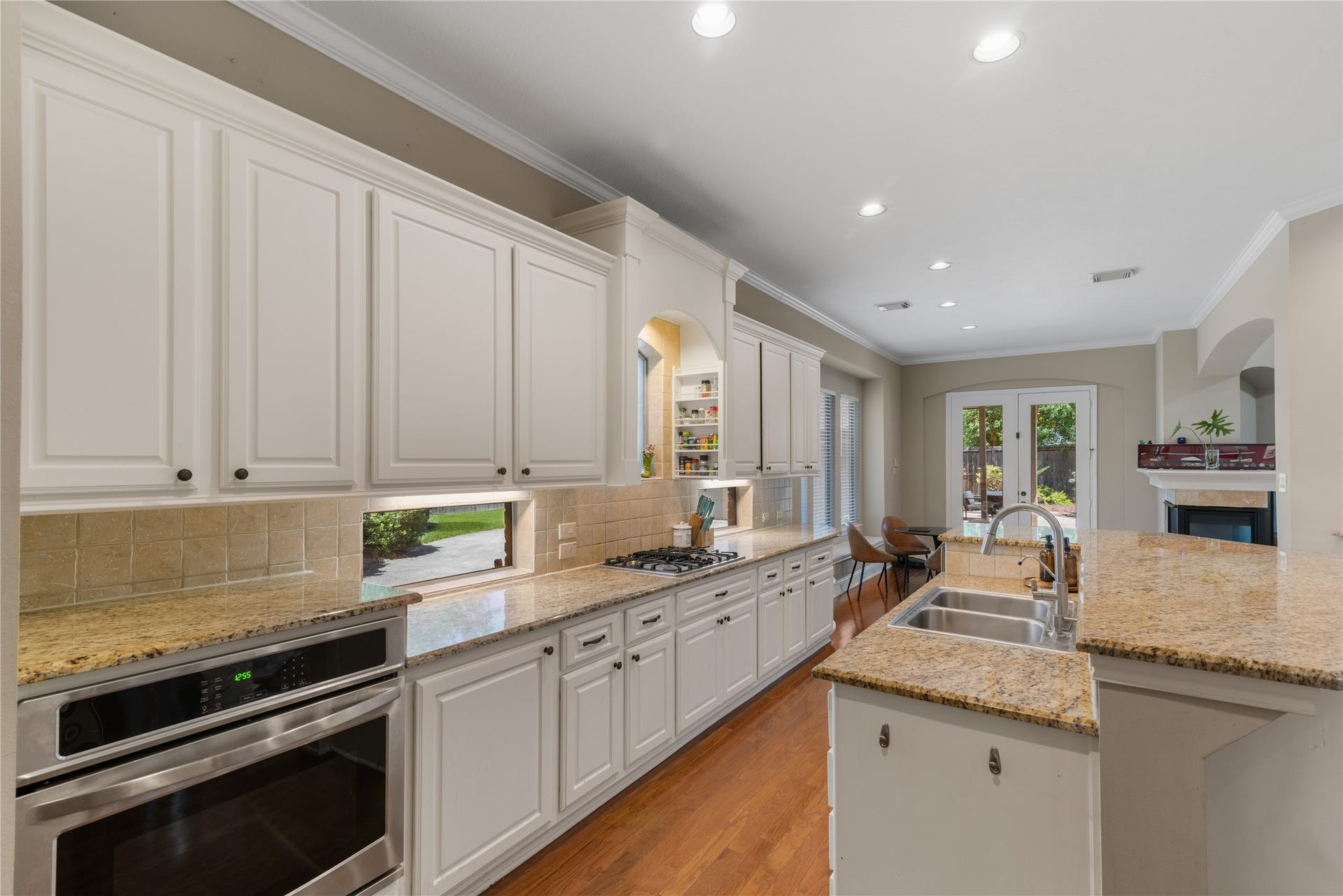 2525 W Ranch Drive, Friendswood, TX 77546 Spacious kitchen featuring white cabinetry, granite countertops, stainless steel appliances, and warm toned flooring.