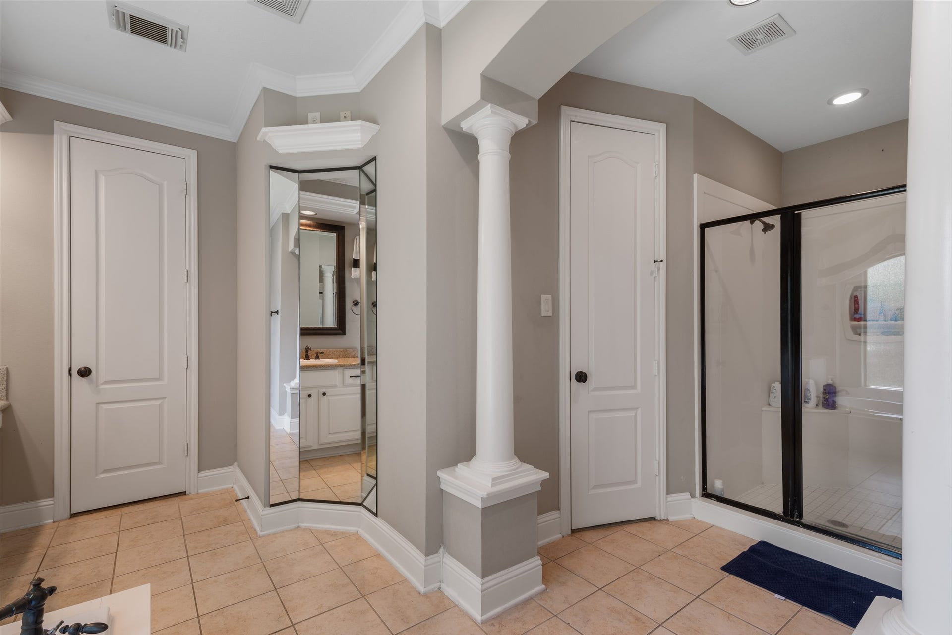 2525 W Ranch Drive, Friendswood, TX 77546 Beautifully designed bathroom with separate glass-enclosed shower, tile flooring, recessed lighting, and elegant architectural details.