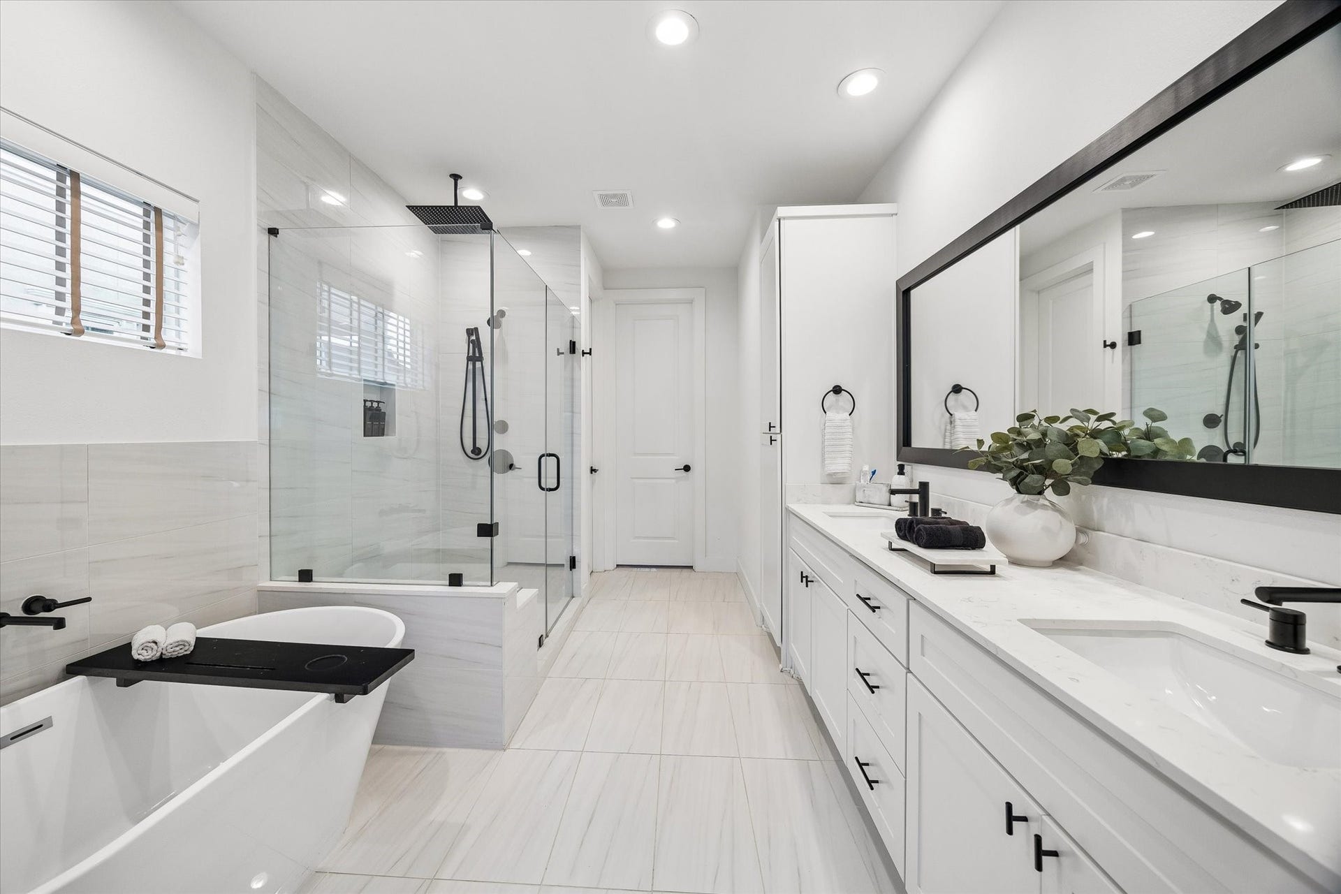 956 Dunleigh Meadows Lane, Houston, TX 77055 The spa-inspired primary bath features dual vanities, quartz surfaces, a spacious walk-in shower, and elegant designer finishes.