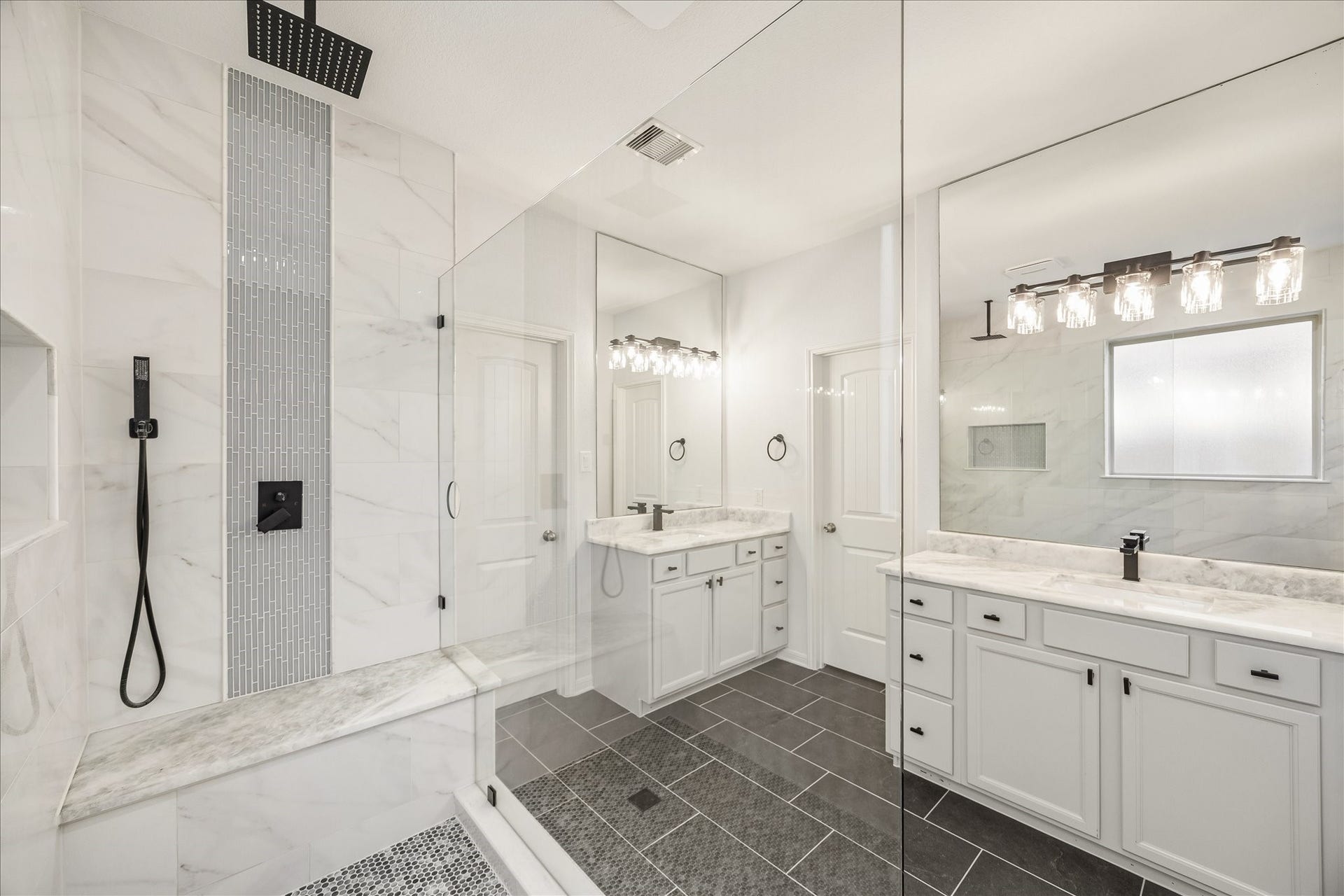 30 Glade Park Drive, Missouri City, TX 77459 Morning and evening routines just got a makeover in this beautiful primary bathroom. Separate vanities with plenty of counter space, full mirrors, and stylish lighting make getting ready a pleasure, while crisp white cabinetry and sleek black tile add a sophisticated touch.