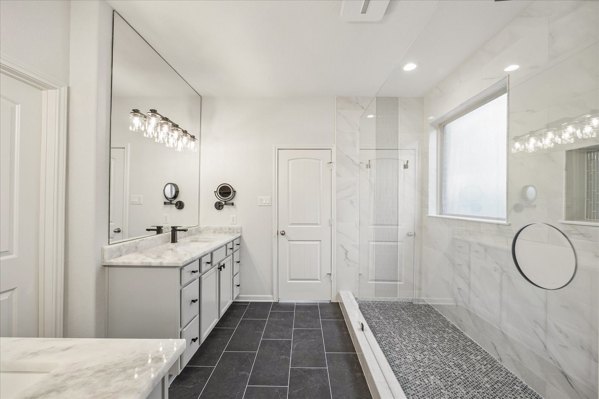 30 Glade Park Drive, Missouri City, TX 77459 This spa-like ensuite offers an oversized walk-in shower and separate vanities, all wrapped in crisp, modern finishes. Beautiful designer tile, frameless glass, stylish lighting, and plenty of counter space create a relaxing retreat where you can start or end your day in comfort and style.