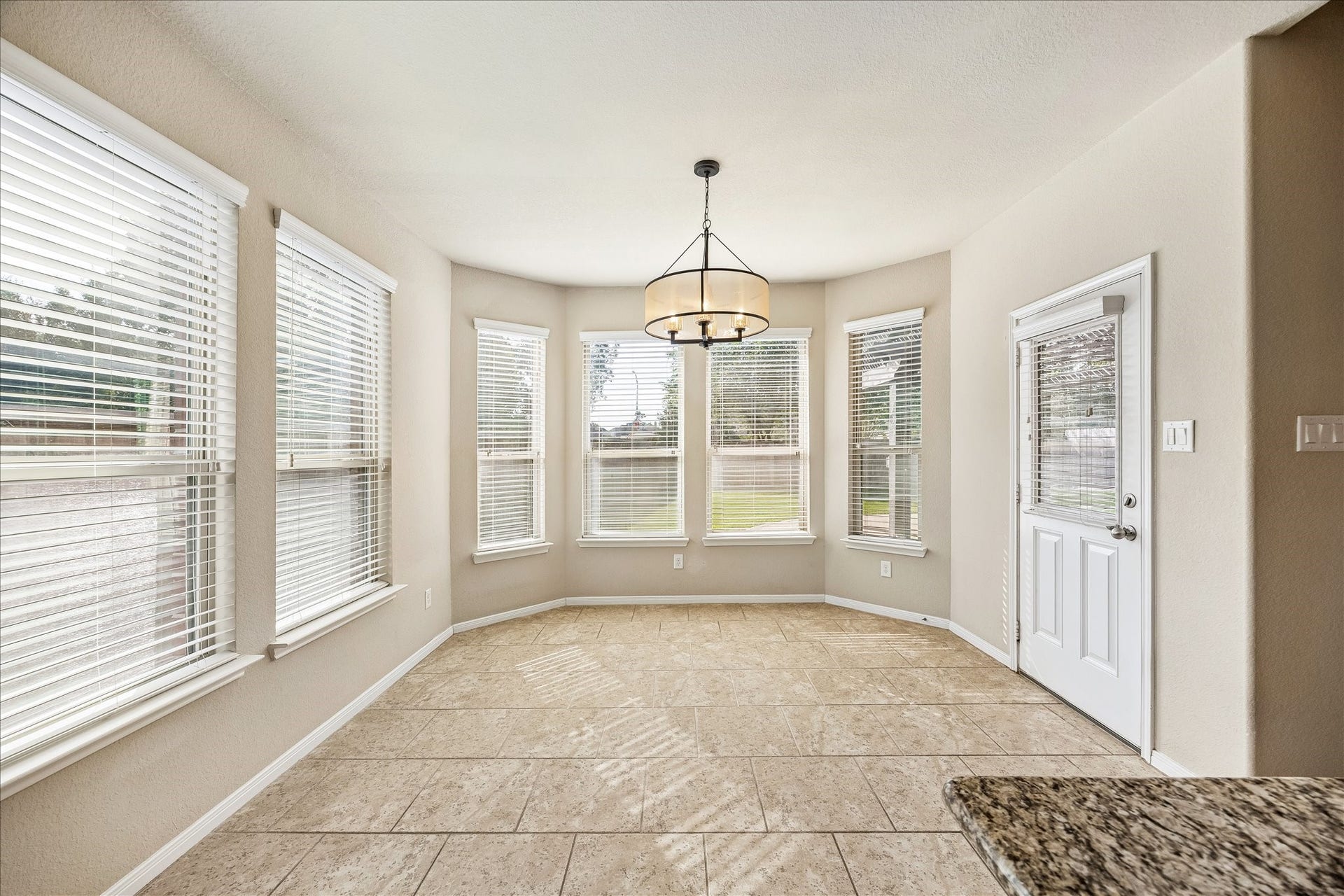 30 Glade Park Drive, Missouri City, TX 77459 Savor your morning coffee with a lovely backyard view. Surrounded by windows and topped with a stylish chandelier, this cheerful breakfast area offers a peaceful spot to start the day.