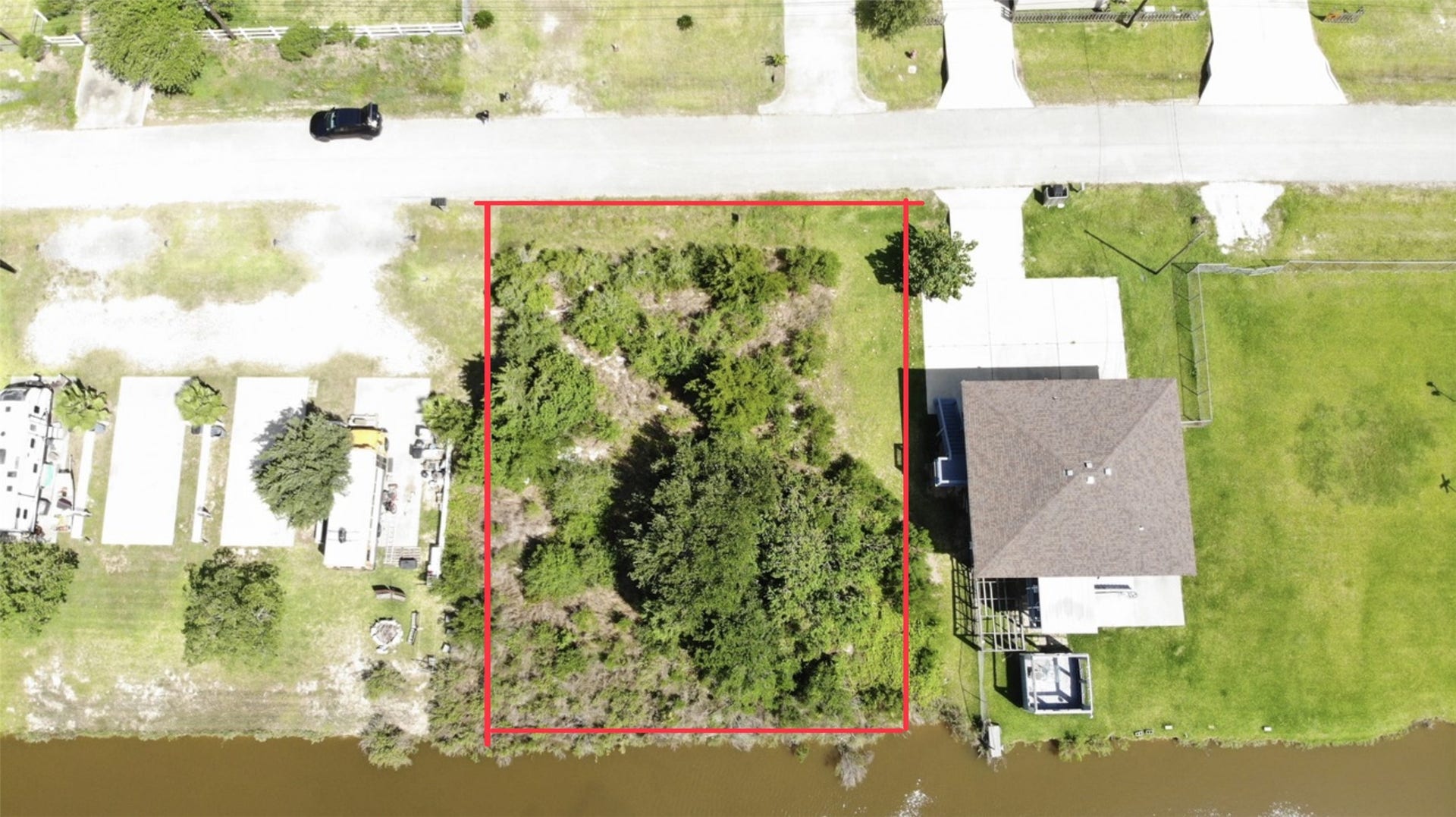 O Schlitz, Hitchcock, TX 77563 Aerial view shows a lot outlined in red, offering potential for development in a quiet residential area.