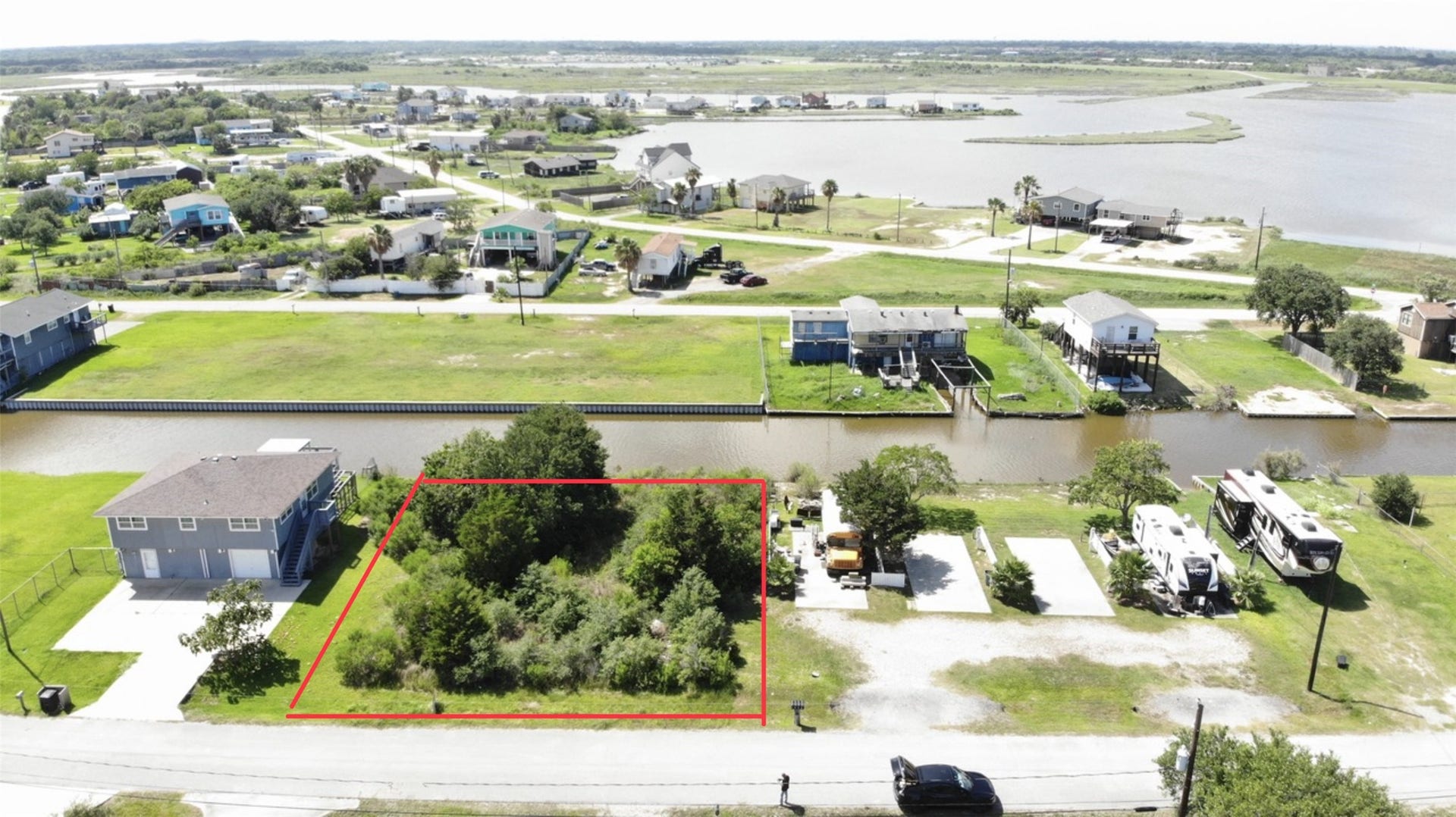 O Schlitz, Hitchcock, TX 77563 lot outlined in red, situated in a residential area by a canal. The neighborhood features water views, offering a serene setting with easy access to water activities.