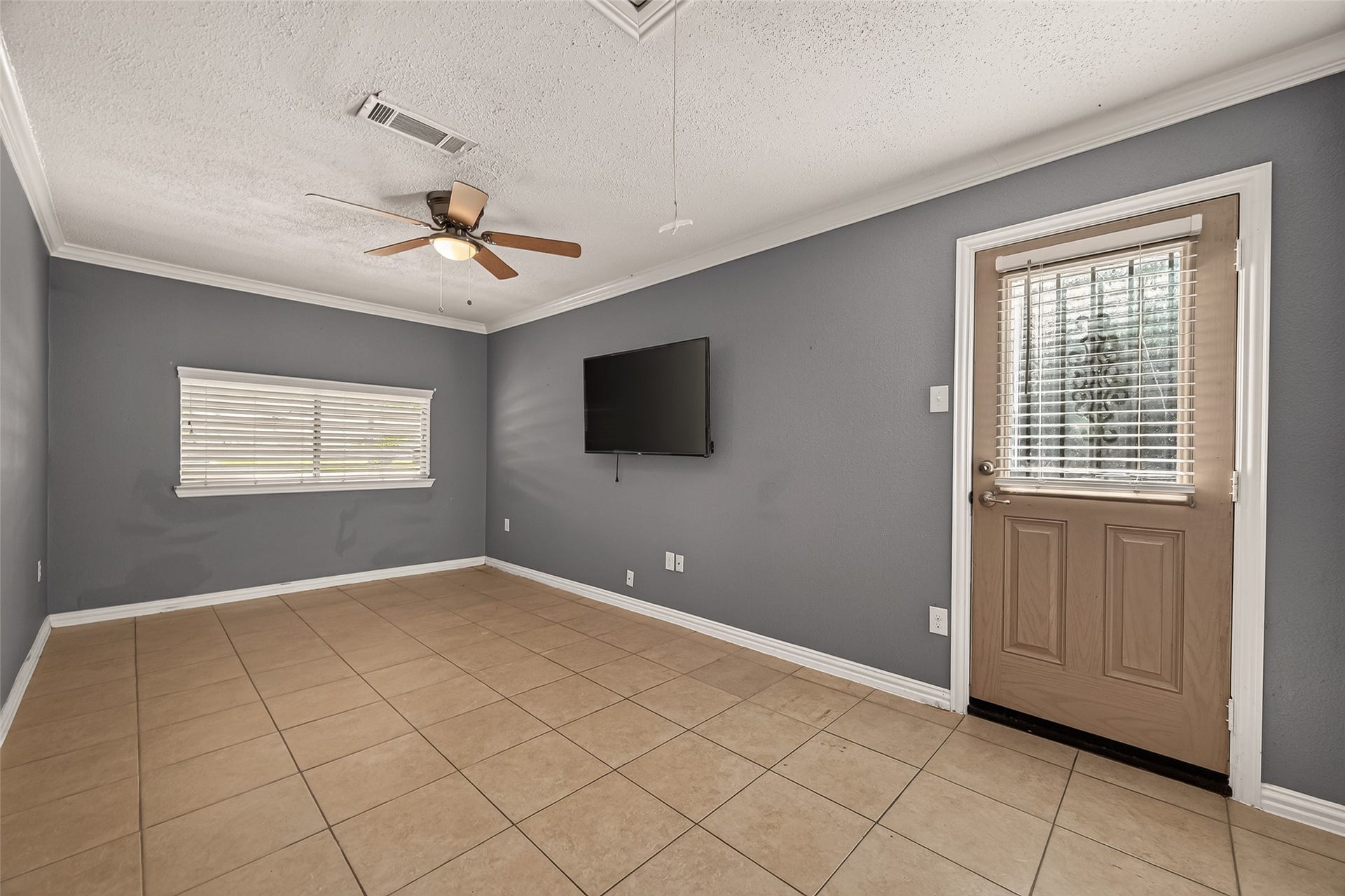 7502 Nightingale Circle, Texas City, TX 77591 Flexible living area with tile flooring, crown molding, ceiling fan, and French doors. Perfect as a home office, den, game room, or hobby space.