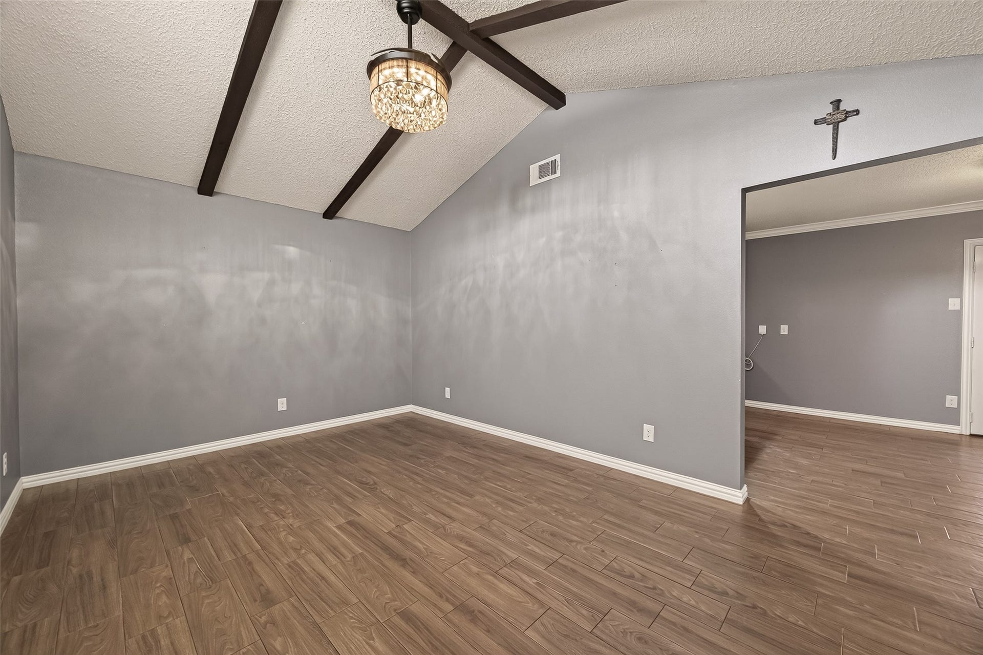 7502 Nightingale Circle, Texas City, TX 77591 The living room showcases dramatic vaulted ceilings with exposed beams, updated lighting, and low-maintenance wood-look flooring, offering both character and comfort.