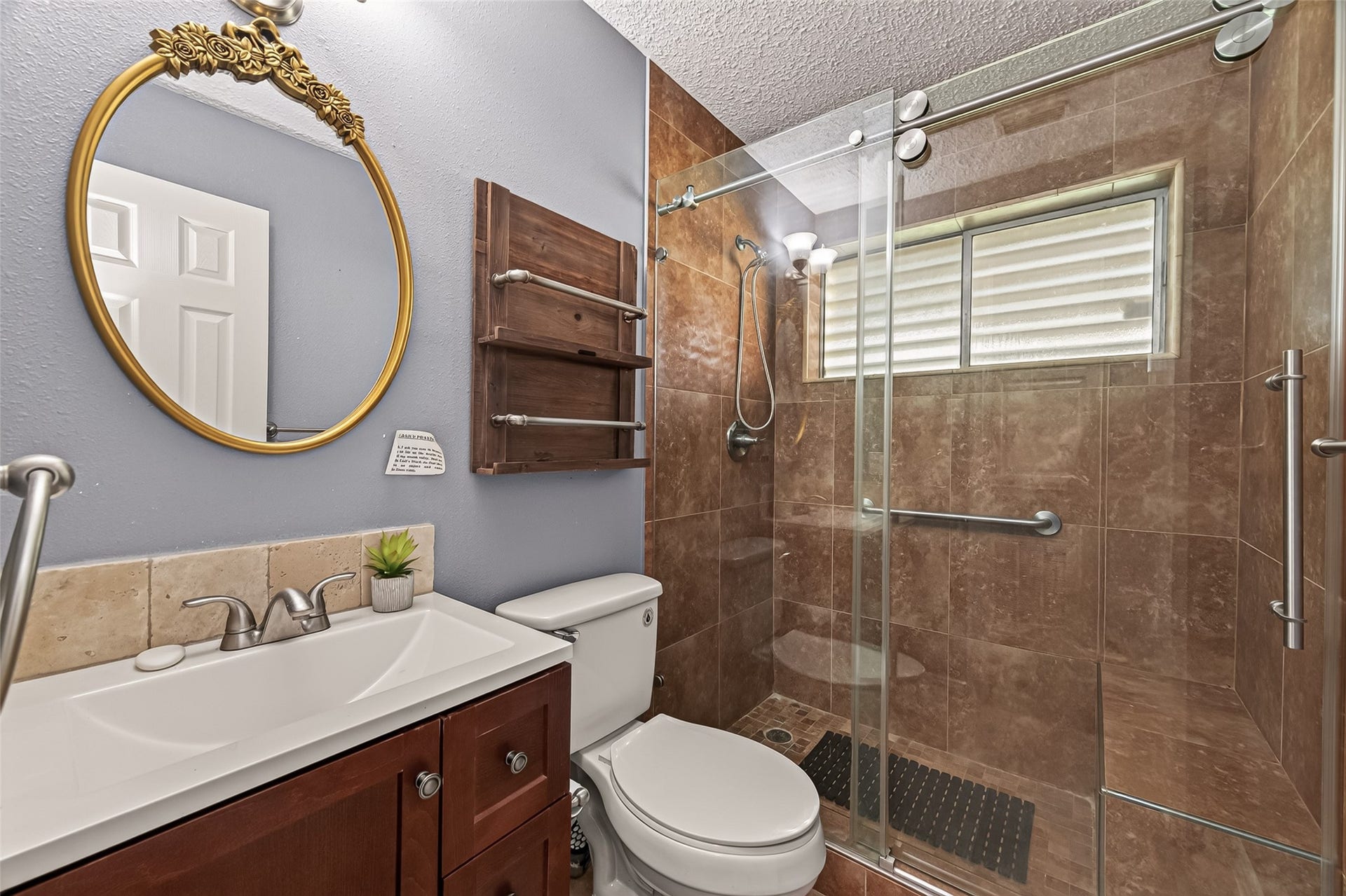7502 Nightingale Circle, Texas City, TX 77591 Updated bathroom with a large walk-in tiled shower, frameless glass enclosure, built-in bench, modern vanity, and abundant natural light. Thoughtfully designed for both style and functionality.